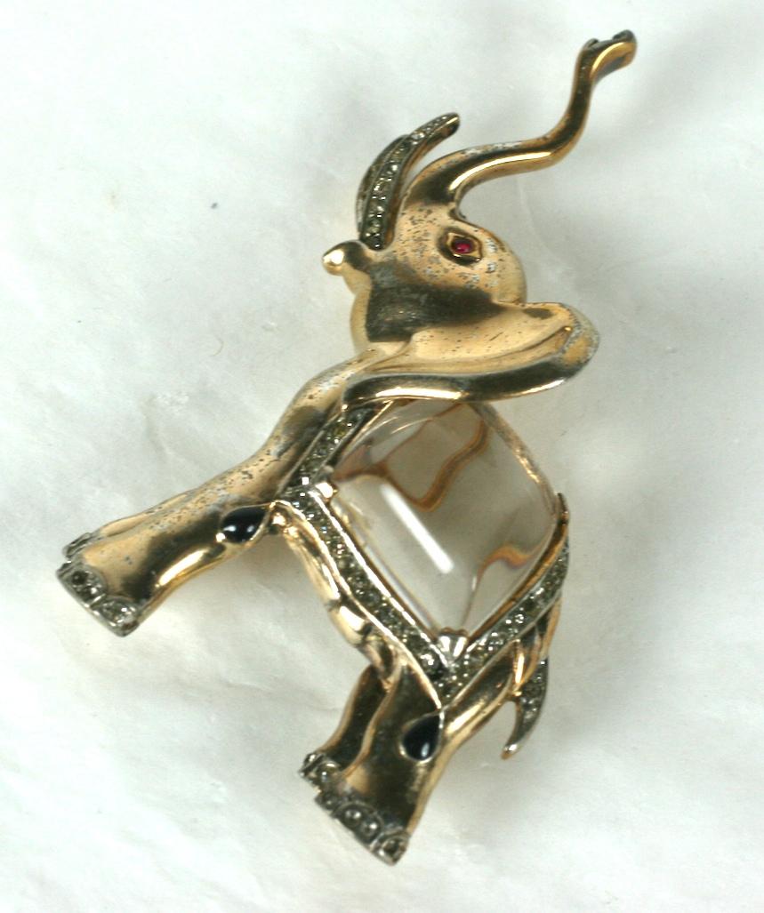 Rare Trifari Alfred Philippe trumpeting  elephant Jelly Belly brooch of gold plated sterling silver with teardrop faux sapphire cabochons and crystal rhinestone pave. The Jelly Belly of molded and hand finished lucite. 
Signed Trifari with Crown,