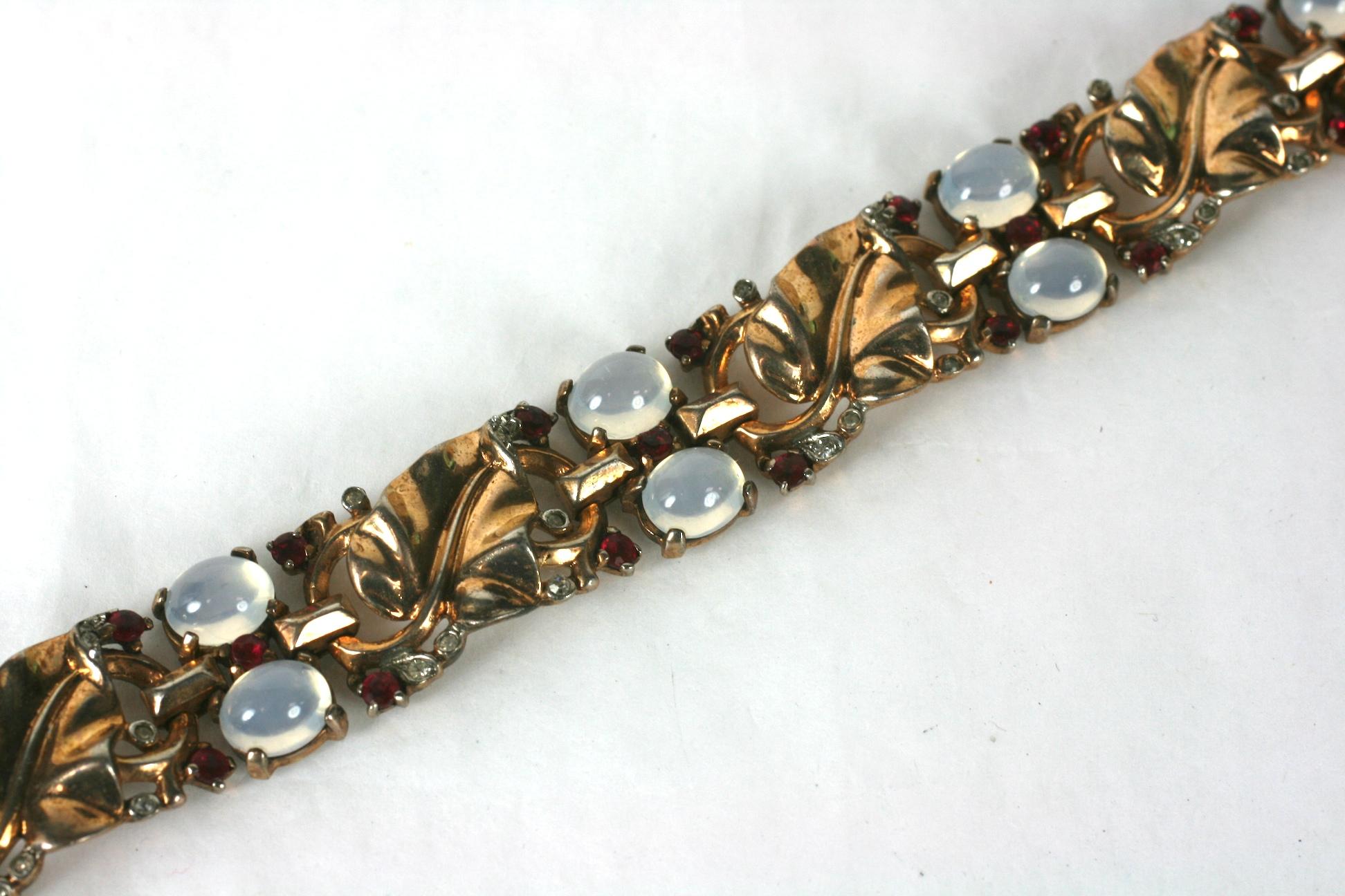 Trifari,  Alfred Philippe Retro sterling vermeil golden leaf link bracelet of faux moonstone cabochons and ruby crystals. Each leaf panel is further accented in minute crystal pave rhinestones.
Marked: Trifari with Crown
Des Pat No 140780,