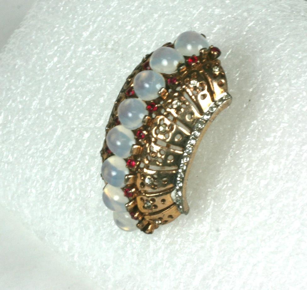 Trifari rose gold plated sterling silver faux moonstone cabochon clip brooch by Alfred Philippe. This Retro brooch is further enhanced by pierce work, faux rubies and crystal rhinestone pave.
Excellent Condition, Signed. 1940's USA.
Clip back