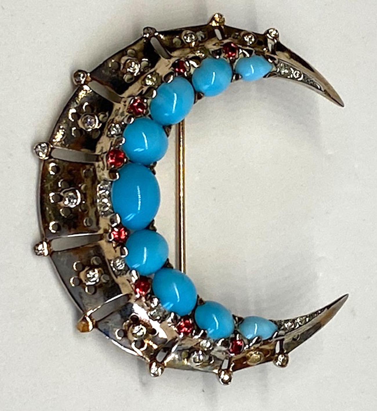 A very nice older Trifari sterling silver with glass turquoise cabochon and red rhinestone accent crescent brooch. Designed by Alfred Philippe, head designer for Trifari, and patented in 1948. Signed Trifari with crown over the T and sterling on the