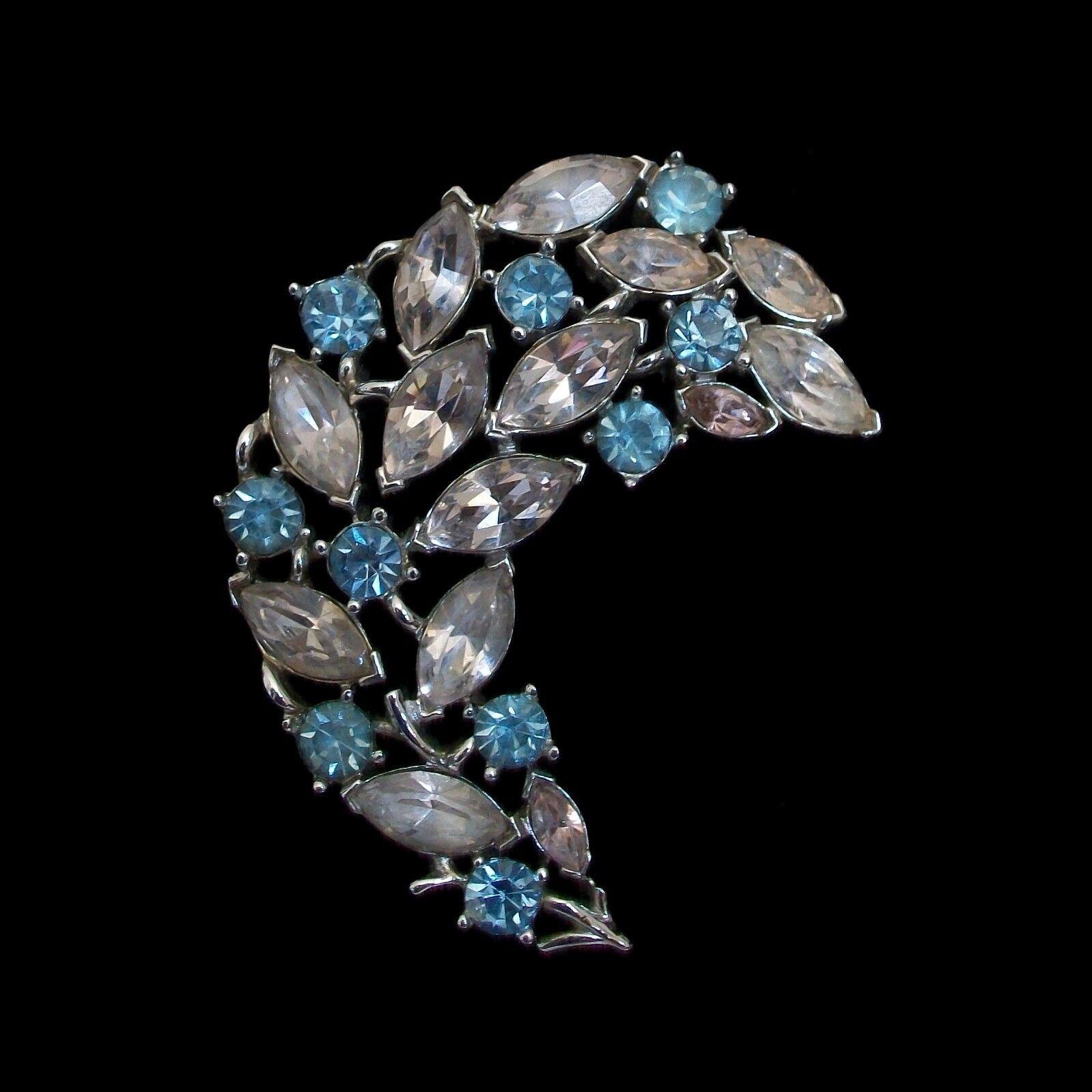TRIFARI  Alfred Philippe - Rare champagne and blue topaz rhinestone 'feather' brooch - rhodium plated frame and back - original safety catch and pin - signed on the back with a crown over the 'T' - U.S.A. - circa 1939-55.

Excellent/mint vintage