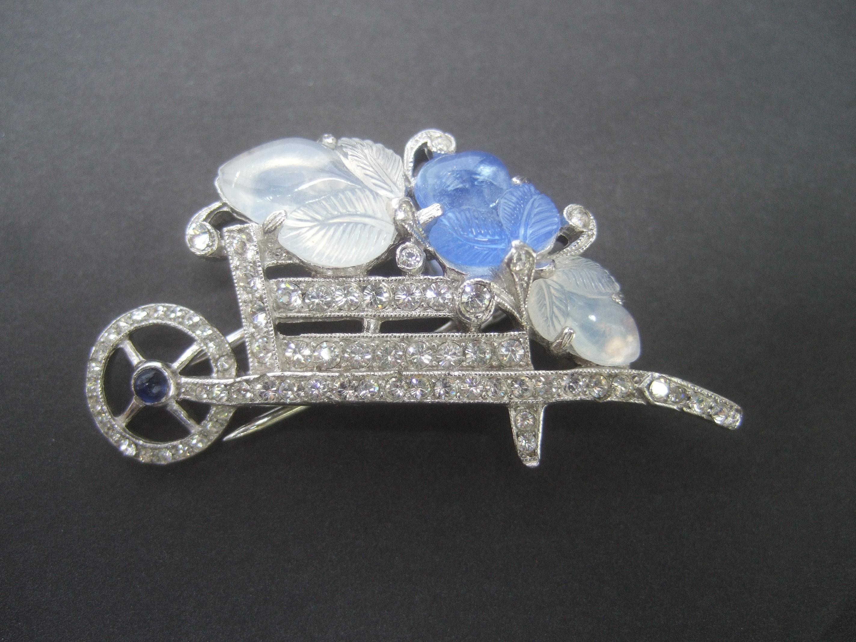 Trifari Art Deco Carved glass diamante crystal wheelbarrow brooch c 1940s

The elegant costume carved glass & diamante crystal brooch emulates precious French jewelry designs from the early 20th century

Alfred Phillipe's previous training in