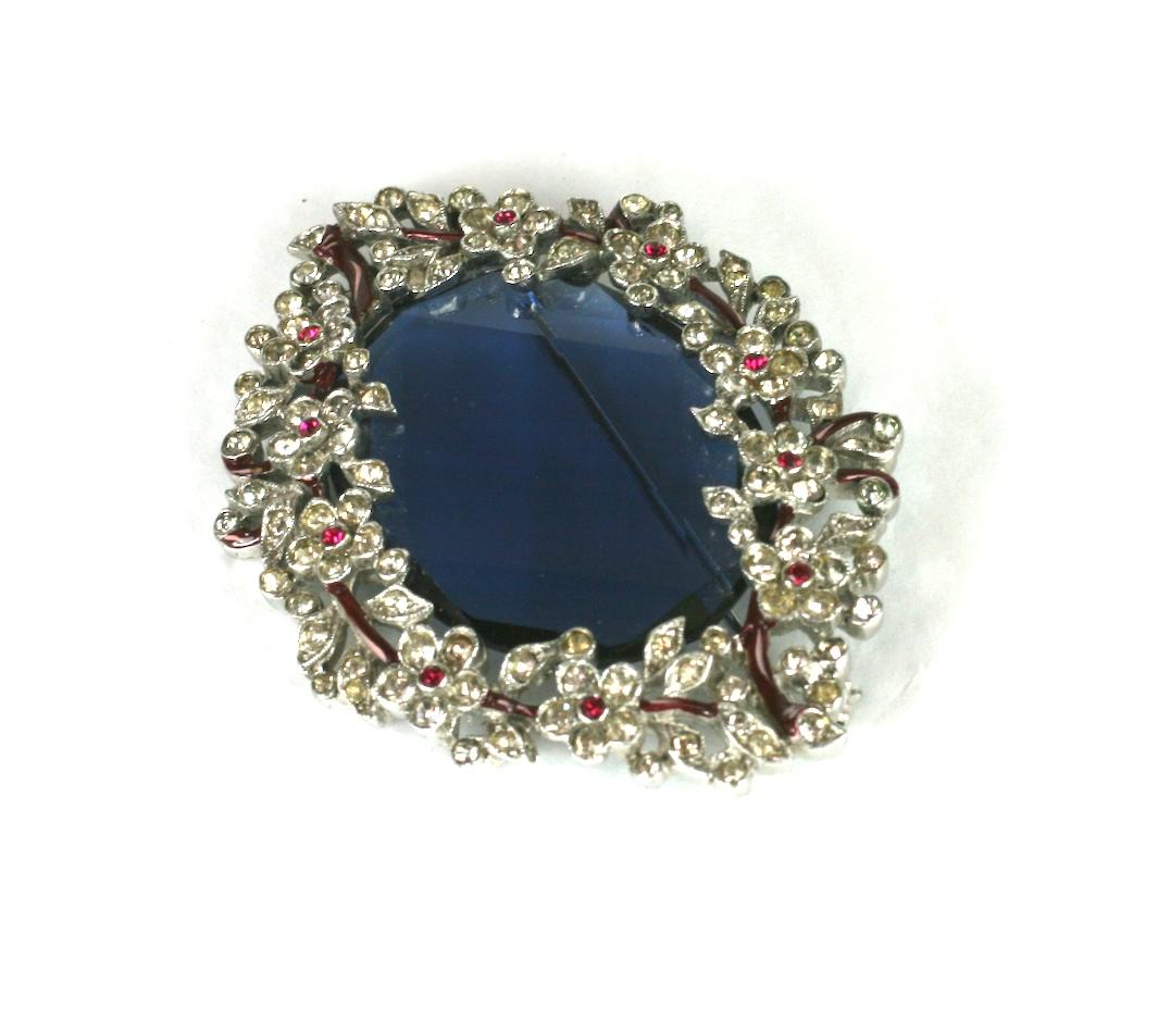 Trifari Art Deco Enamel Pave Brooch surrounding a large faceted sapphire stone. Pave branches are finely detailed with enamel vines and flower heads.  1930's USA. 
Alfred Phillipe for Trifari. 
2.5