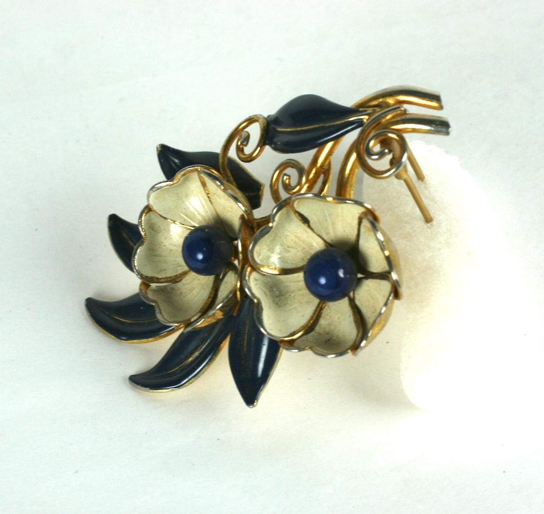 Trifari Art Deco Enameled Flower Clip by Alfred Phillipe. Flowers and leaves are enameled in ivory and navy with lapis glass paste centers. Fur clip fitting.   1930's USA. 
3