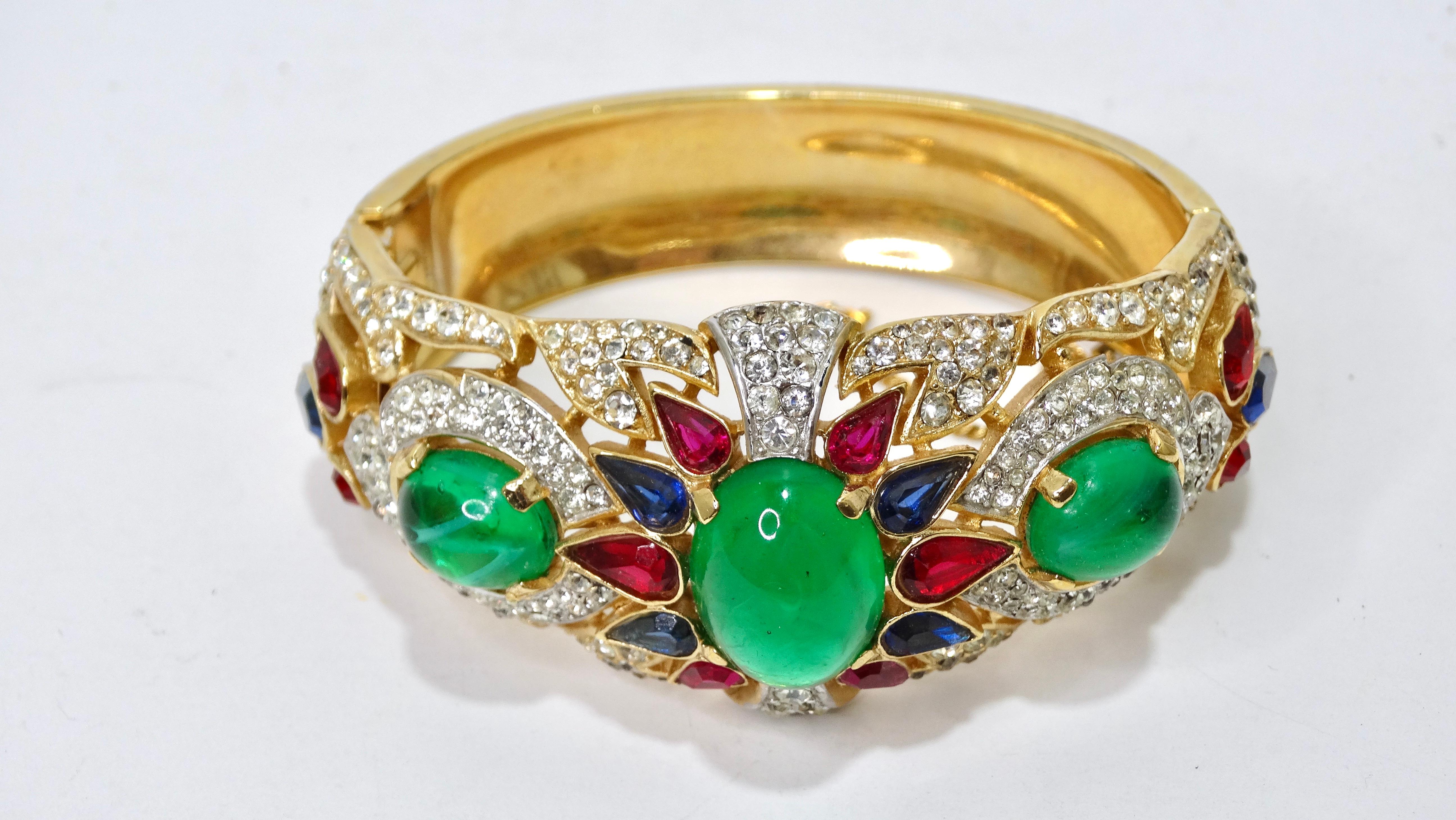 This is a beautiful Trifari bracelet that is completely covered in beautiful faux gemstones. It features three large emerald green stones surrounded by pave clear crystals. This bracelet is bound to create a statement. For your next event, pair it