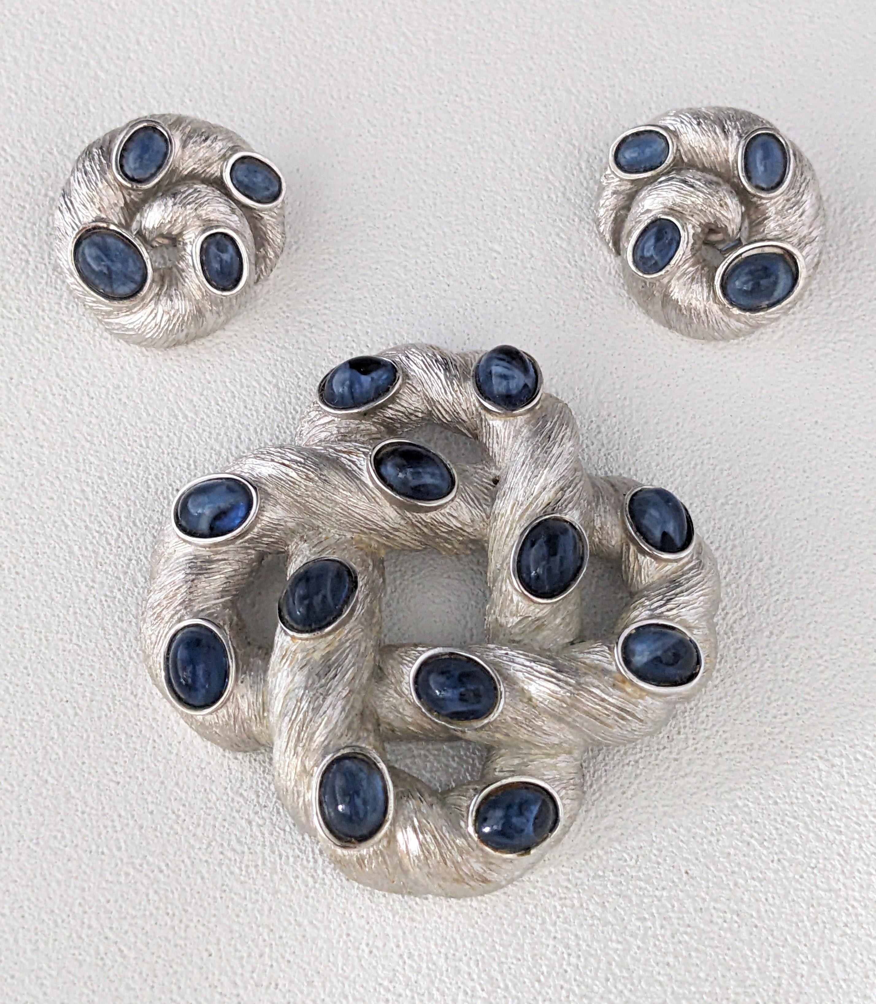 Attractive Trifari Brushed Silver and Sapphire Cab Suite from the 1960's. Brushed silvertone metal with faux sapphire cabochons. 1960's USA. 2.5