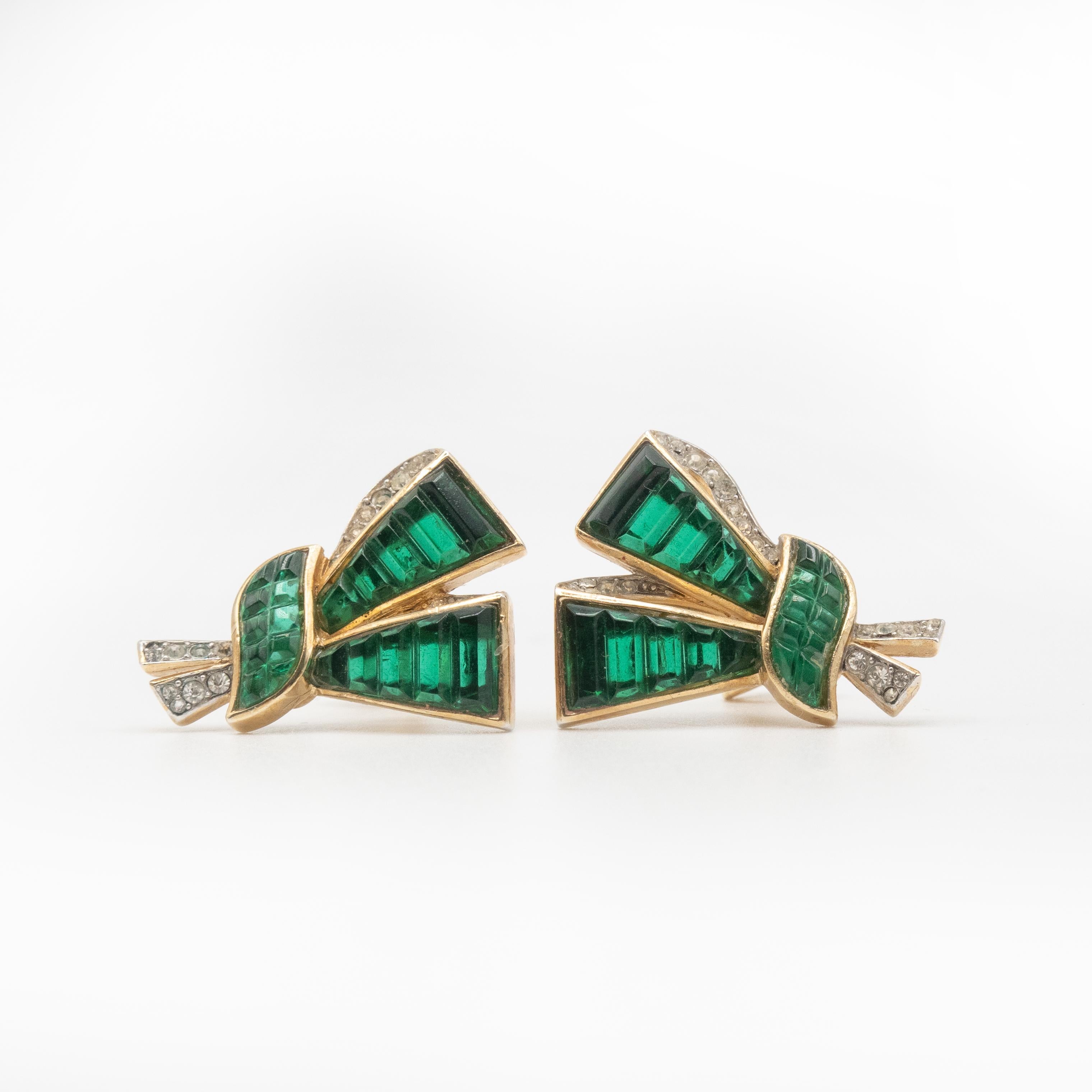 Fabulous Trifari Invisible set Knotted Bow Clip-on Earrings designed by Alfred Philippe set with green emerald glass and white rhinestones.
Marked Crown TRIFARI and copyright, and this mark is between 1955 to 1969

Approximate Measurement: 1.18” x