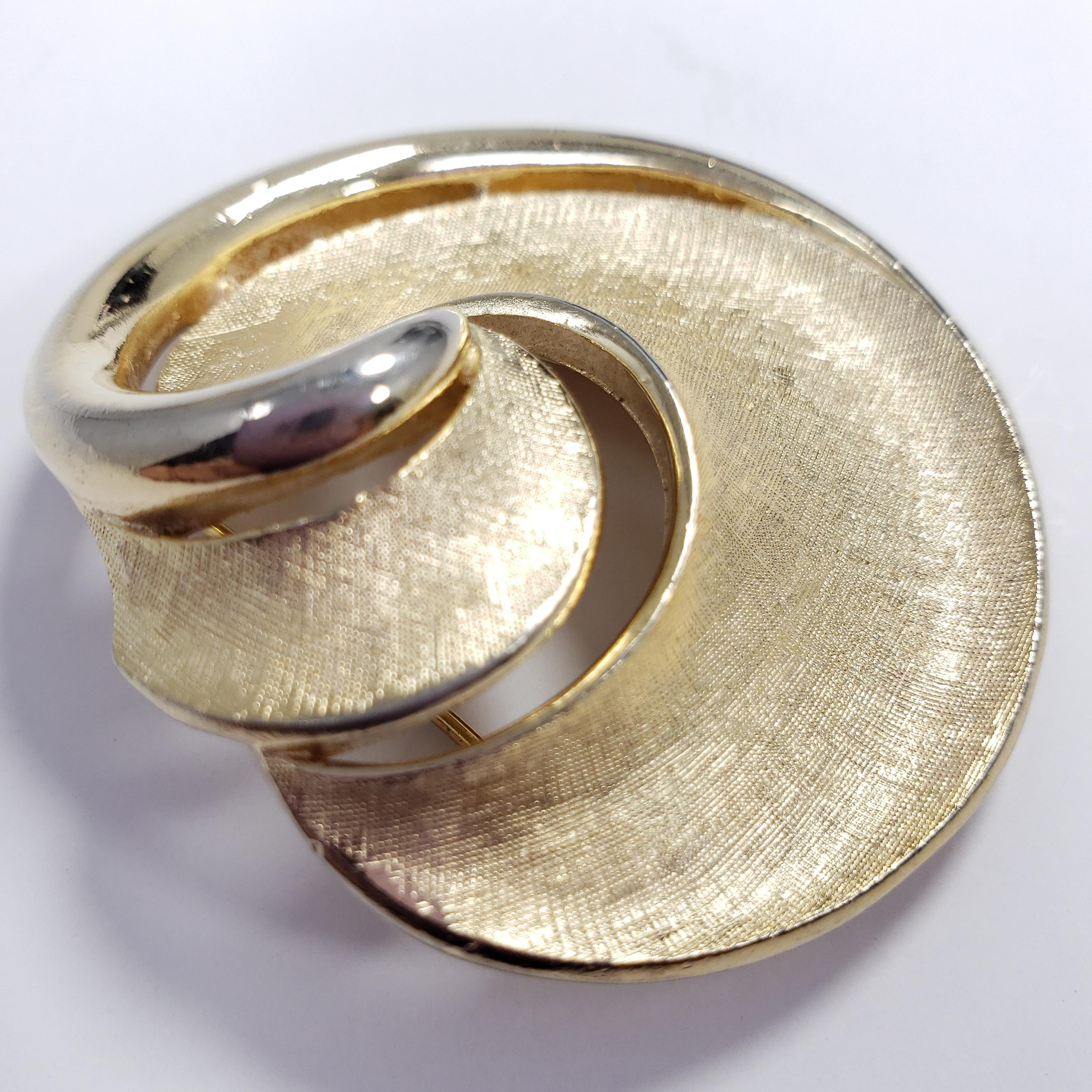 A sophisticated Crown Trifari pin brooch, featuring a textured gold decorative motif in the classic Trifari style.

Hallmarks: Trifari © 