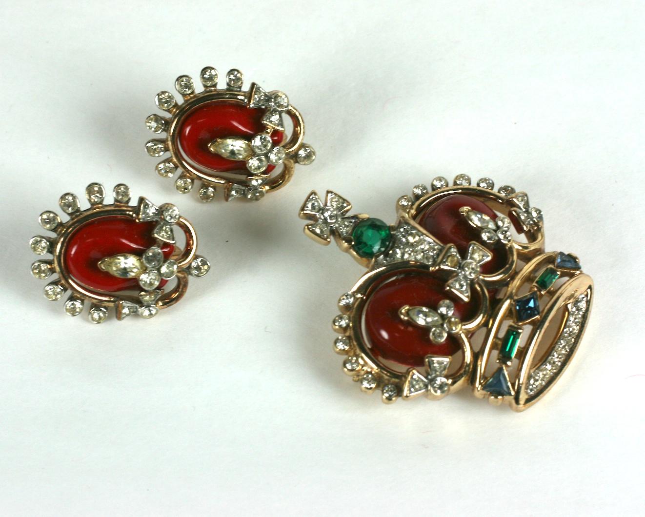 Trifari Alfred Philippe Coronation Gems Red Royal Crown  brooch and matching earclips in the original presentation box.
Gold and rhodium plate base metal, crystal, emerald, sapphire rhinestones with and cold enameling.
Condition: Excellent  Marked