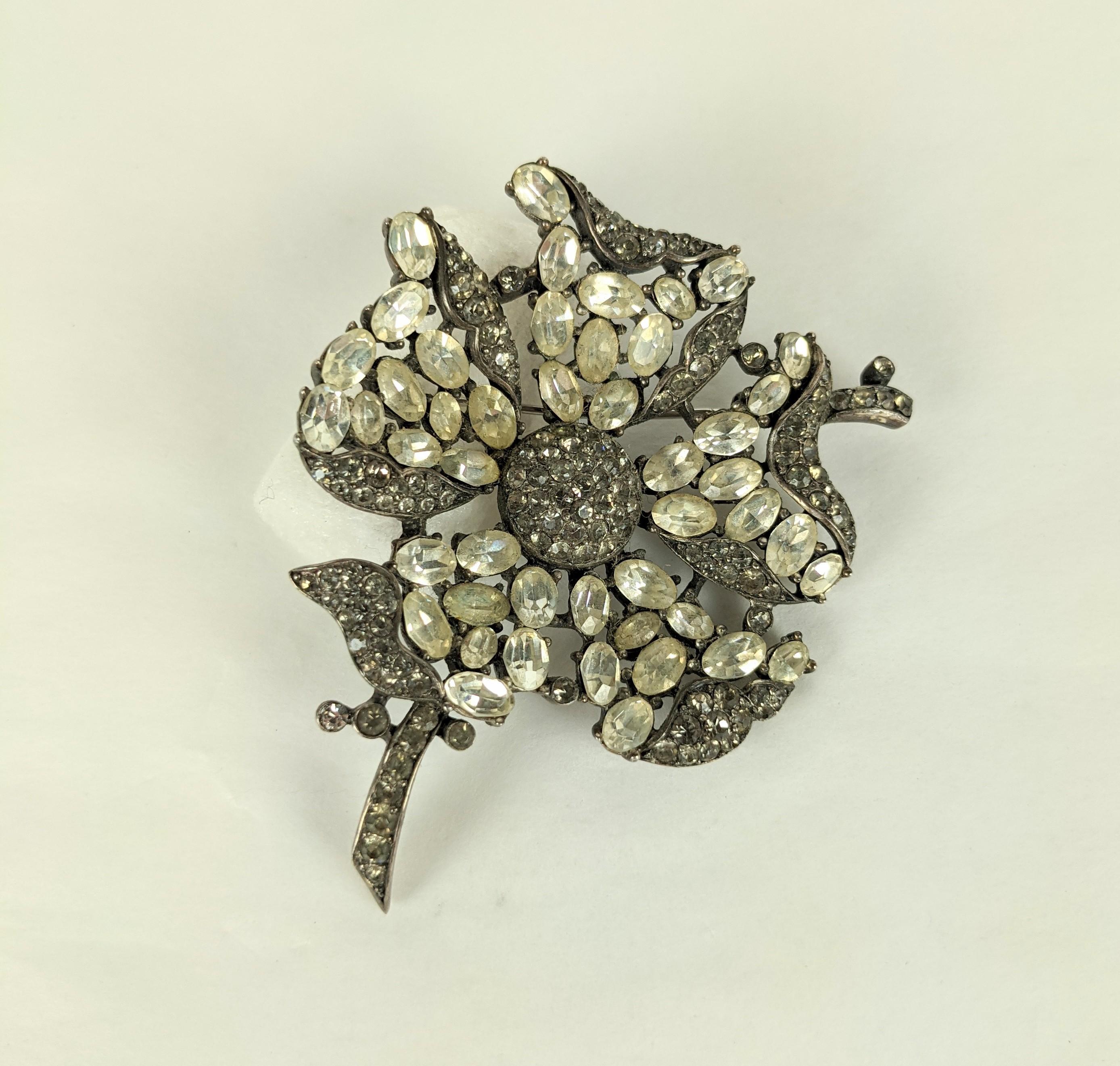 Trifari Crystal Flower Brooch of oval crystals with smoke crystal pave. This collectible Trifari series comes with either crystal or ruby ovals accented by grey crystal pave, very striking combination. 1960's USA. 
Signed Trifari.  2