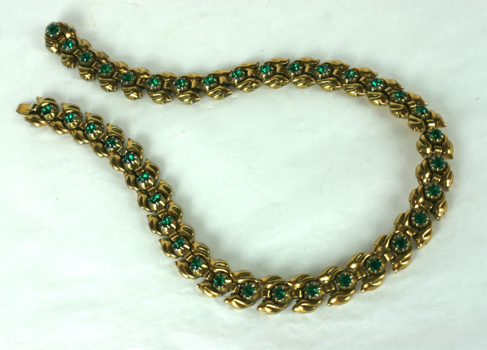 Trifari Eugenie Faux Emerald Necklace set in green gold plate from the 1940's. Each foliate link is set with an emerald crystal which repeats throughout this supple link necklace.  1940's USA. 
16