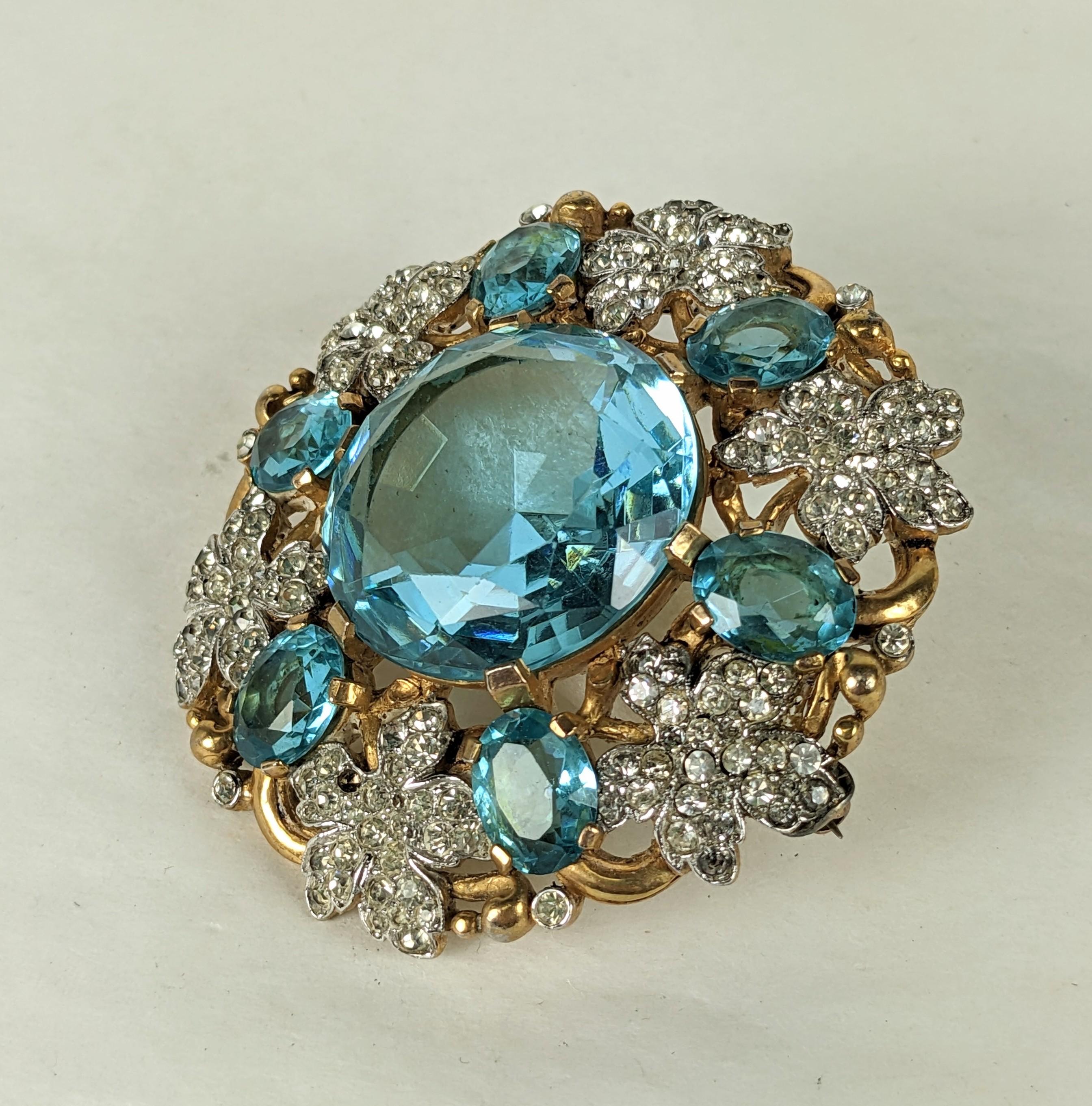 Collectible and rare Trifari Eugenie Series Aquamarine Crest brooch. Large scale with pave leaves set in rhodium with gilt metal vines set with large faux aquamarines. 
Large, extravagant Retro design is dimensional and striking. 1940's USA. 2.5
