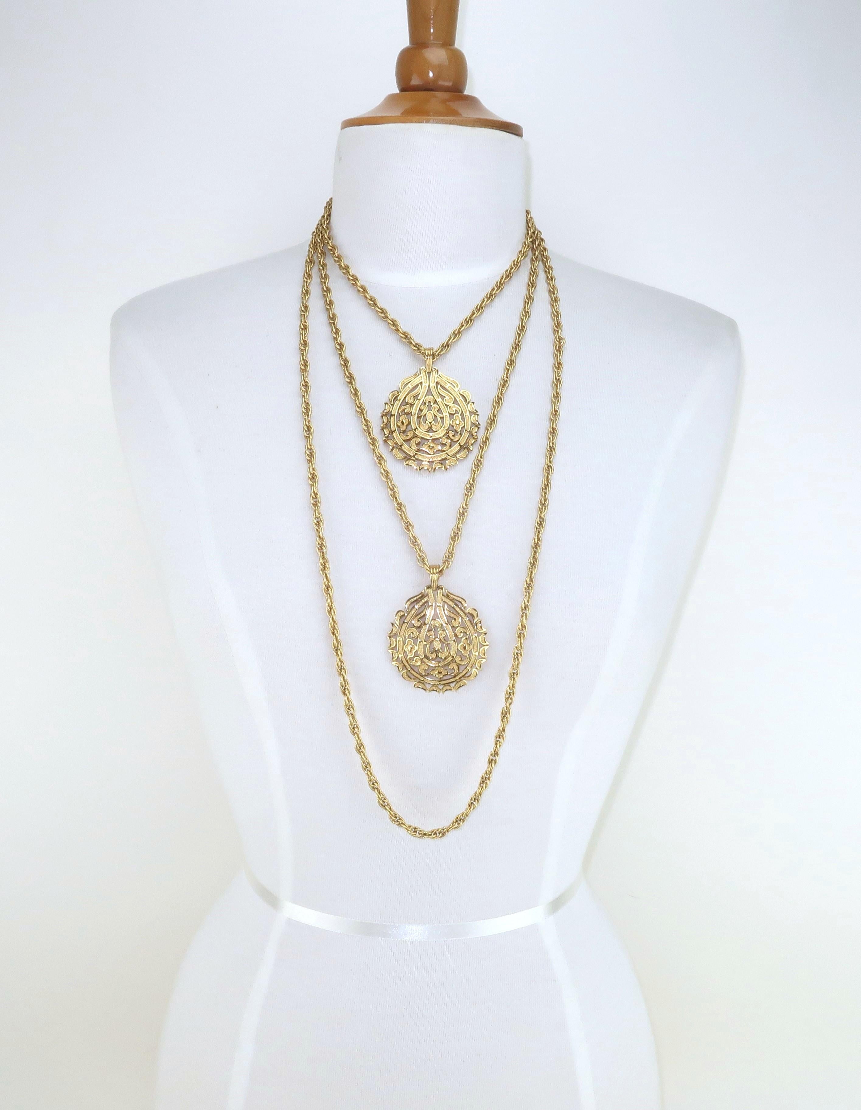 Collar Trifari de oro de 1960 de varias vueltas con colgantes de doble medallón.  El collar está formado por tres cadenas de cuerda trenzada que se enganchan en la parte posterior, dos de las cuales sujetan medallones de filigrana de diseño exótico.