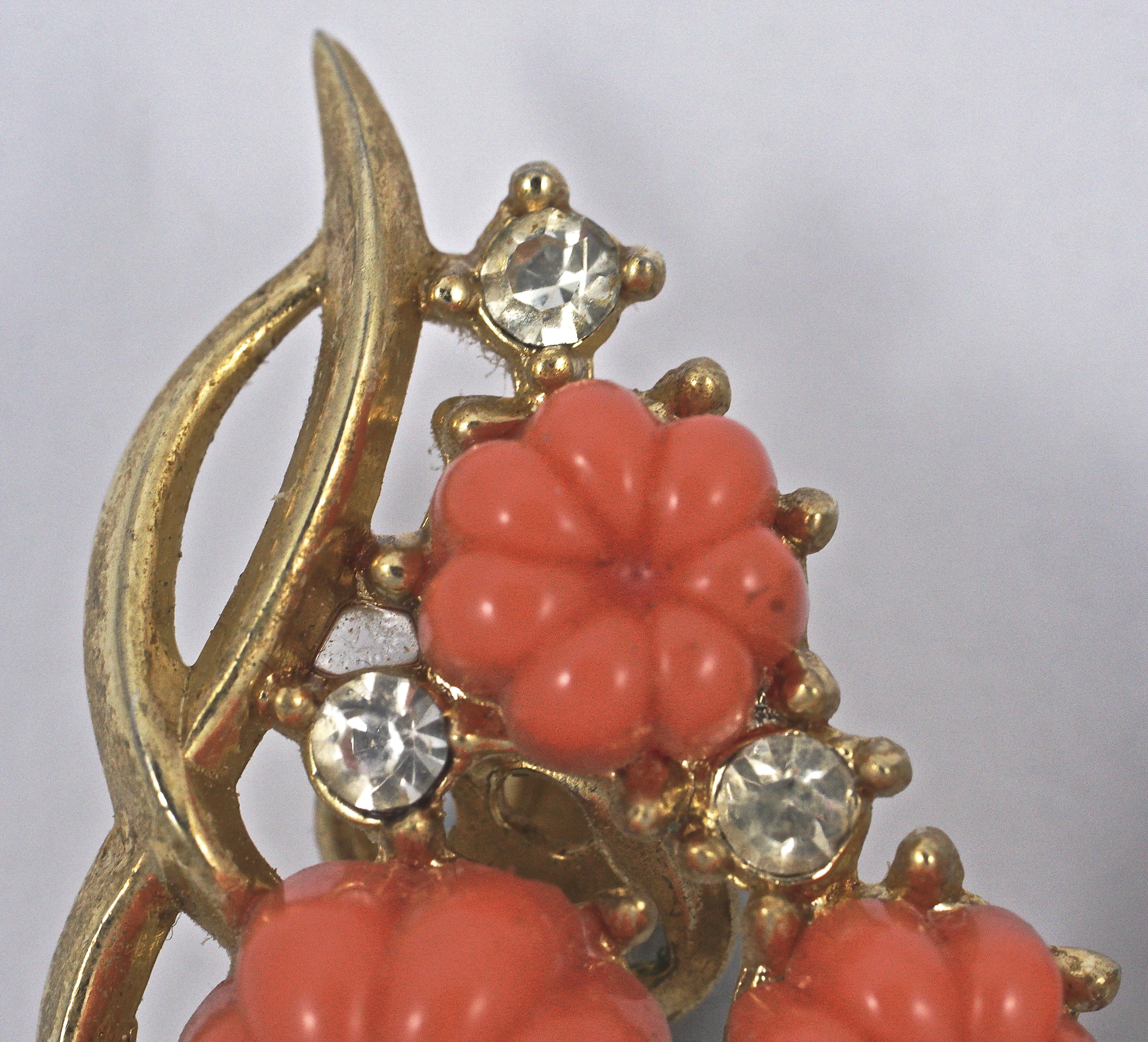 
Beautiful Trifari gold plated fruit salad clip on earrings in an organic shape, featuring moulded coral glass flowers and clear rhinestones. Measuring length 3cm / 1.8 inches by width 2cm / .79 inch. 

This is a lovely pair of older Trifari