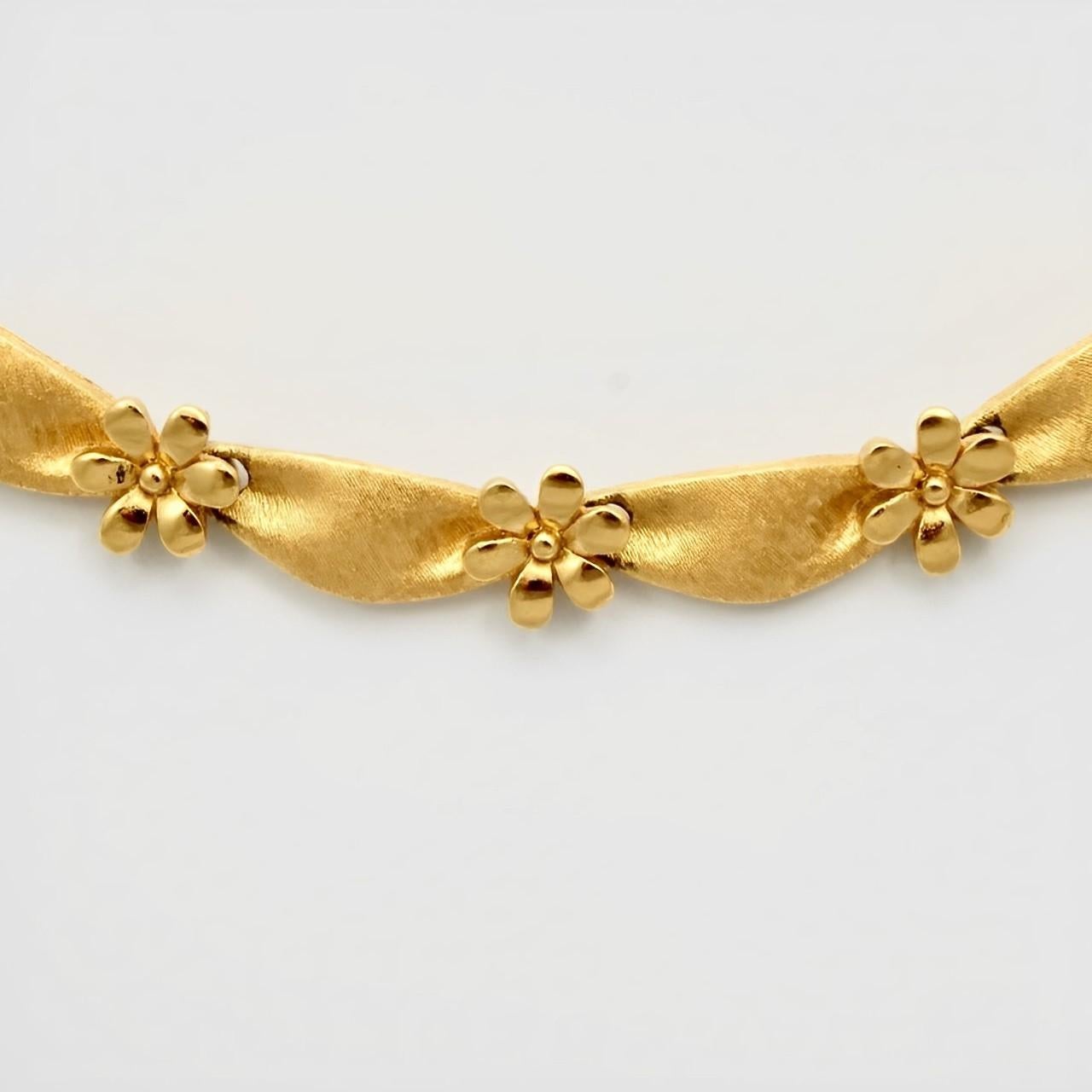 Beautiful Trifari brushed gold plated ribbon design necklace with contrasting shiny flowers. Length 40 cm / 15.75 inches, including the extension, and the flowers are width 9mm / .35 inches. The necklace is in very good condition.

This lovely