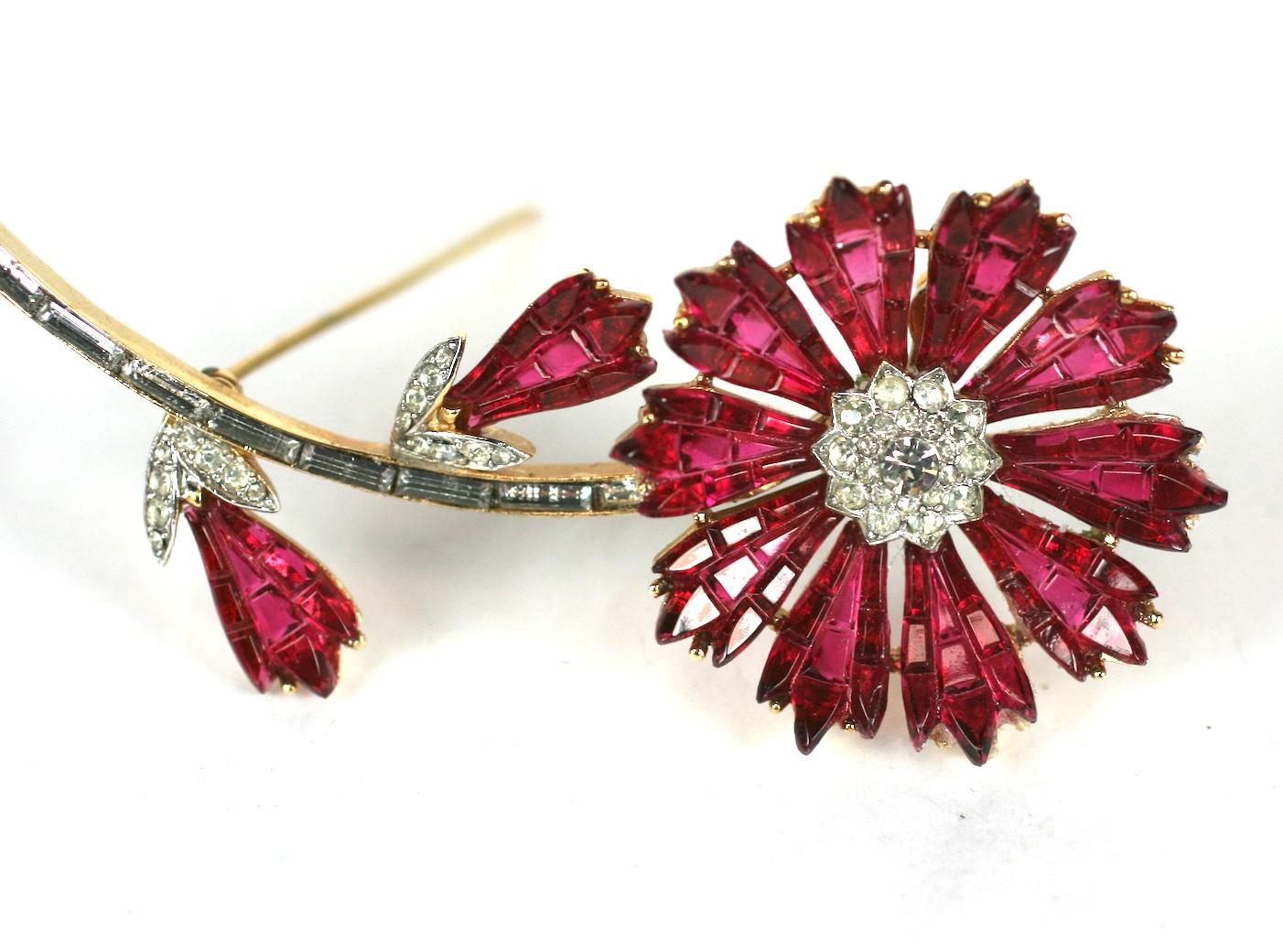 Trifari, Alfred Phillipe Invisibly Set Ruby Flower with ruby waffle glass made to resemble the gem stone settings of Van Cleef and Arpels. Pave cluster center with baguette decorated stem.
Highly collectible Trifari series, 1960's USA. 
Excellent