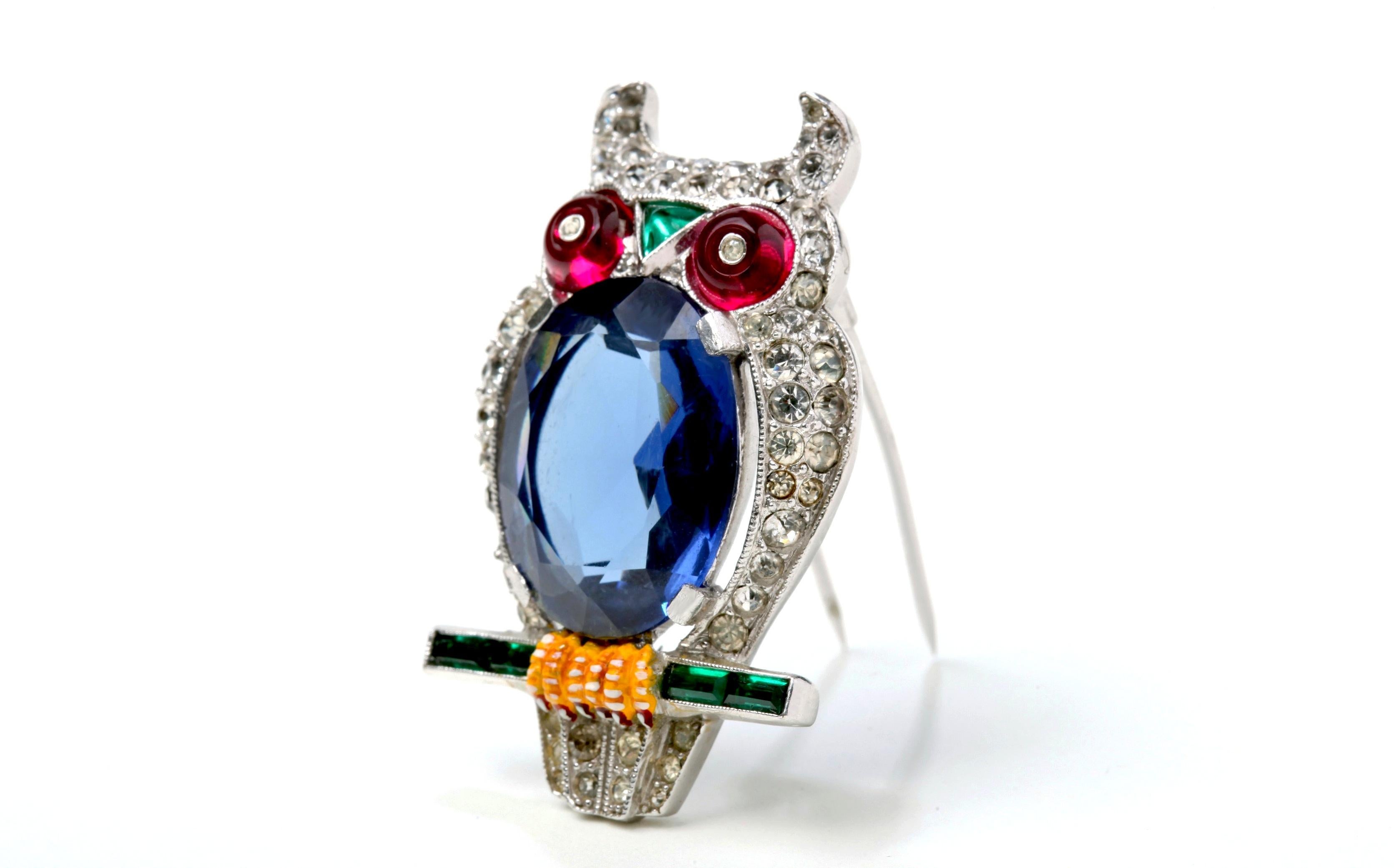 An exceptional 1941 Alfred Phillippe for Trifari Rare Owl Fur Clip Brooch in beautiful condition.  The blue cabochon jelly belly with the fuchsia eyes pop amongst the crystals.  Tiny emerald green cut baguettes create the branch for which he