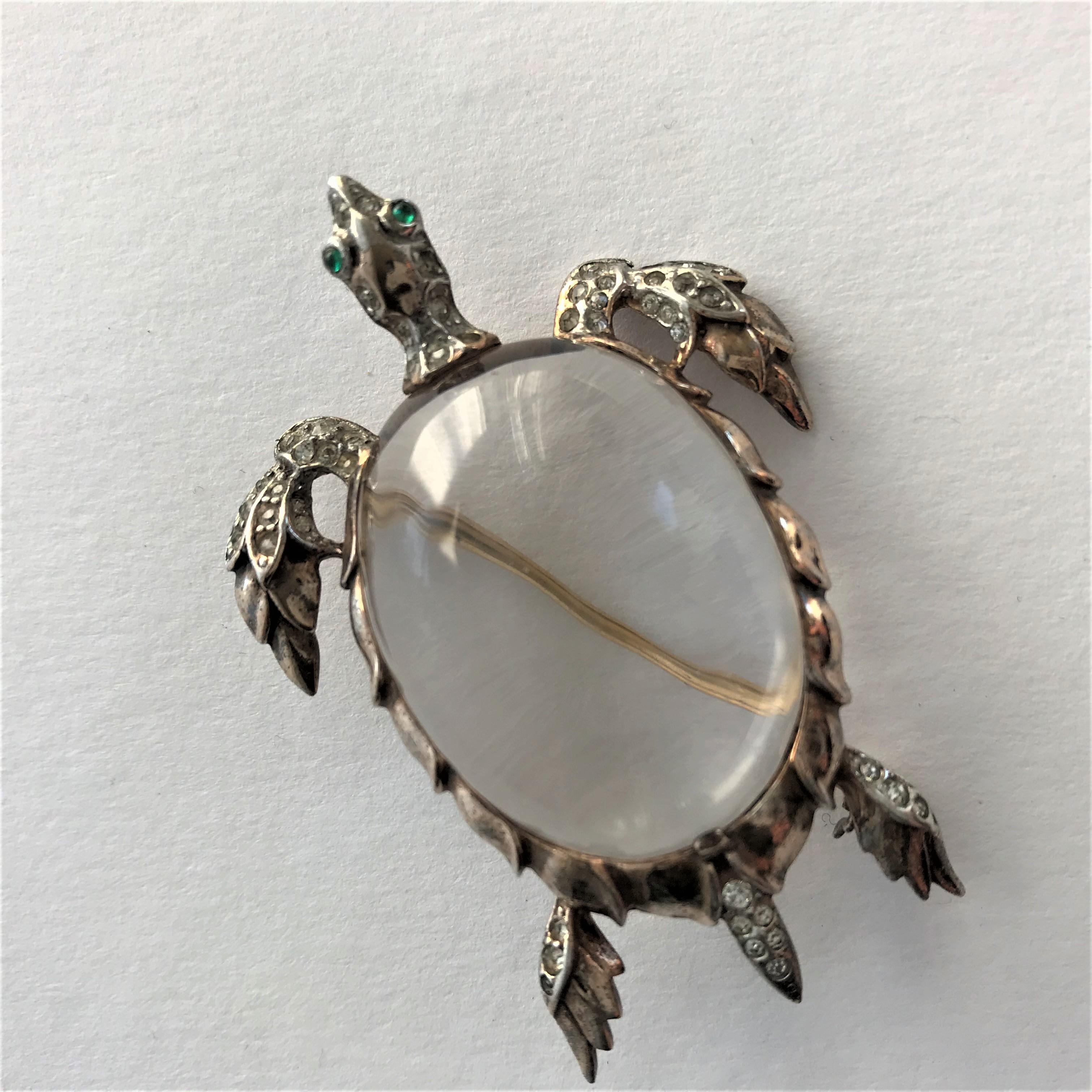 Trifari Jelly  Belly sea turtle brooch crafted of gold plated sterling silver. Embellishments include a large clear Lucite cabochon, called a jelly belly by collectors, with clear rhinestone accents.  Marked Trifari Sterling with a design patent