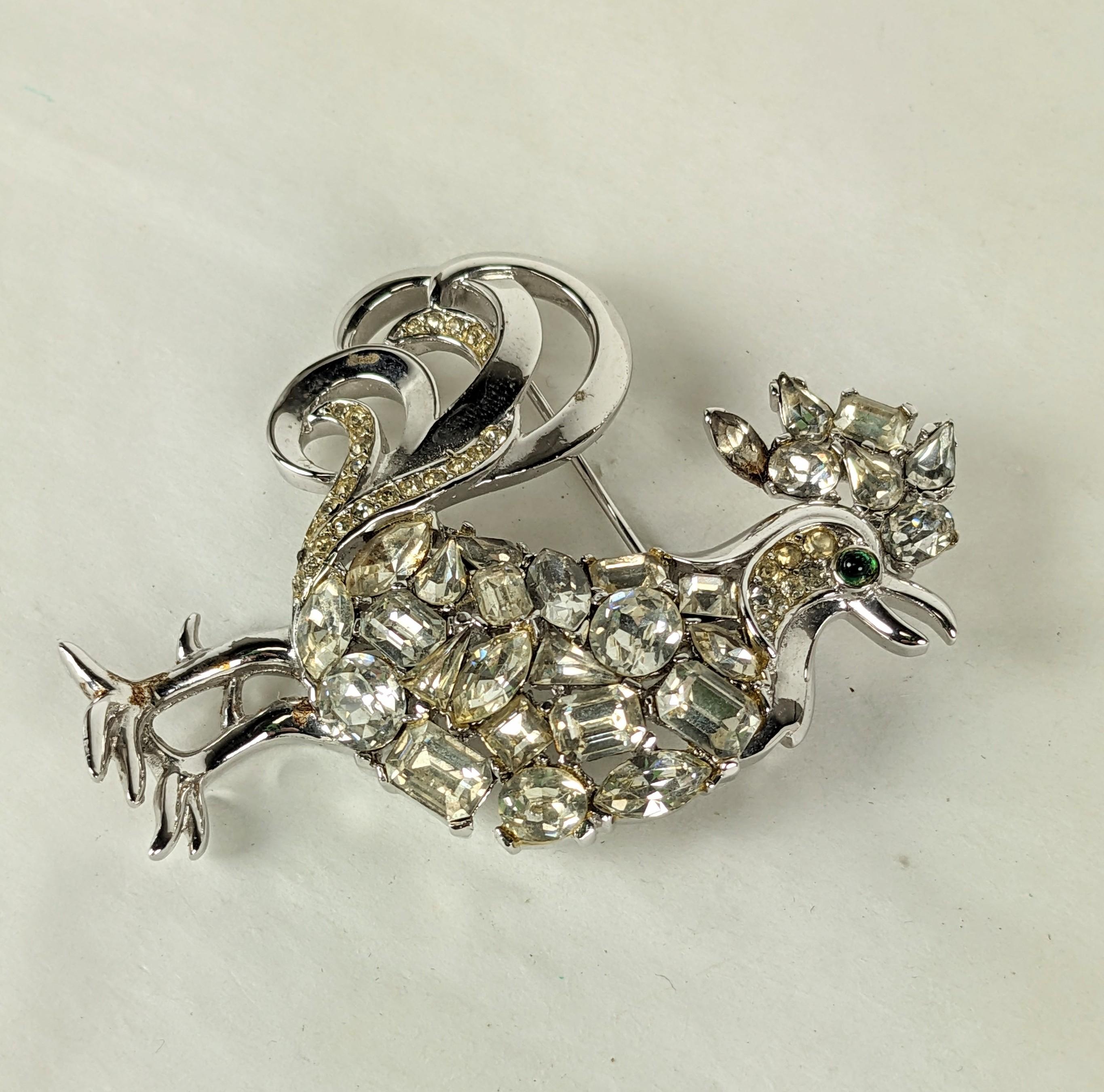 Trifari Jeweled Rooster Brooch from the Jeweled Symphony series from the 1950's. Rhodium plated set with hundreds of vari sized cut pastes and pave with a green cab eye.  
1950's USA. 2