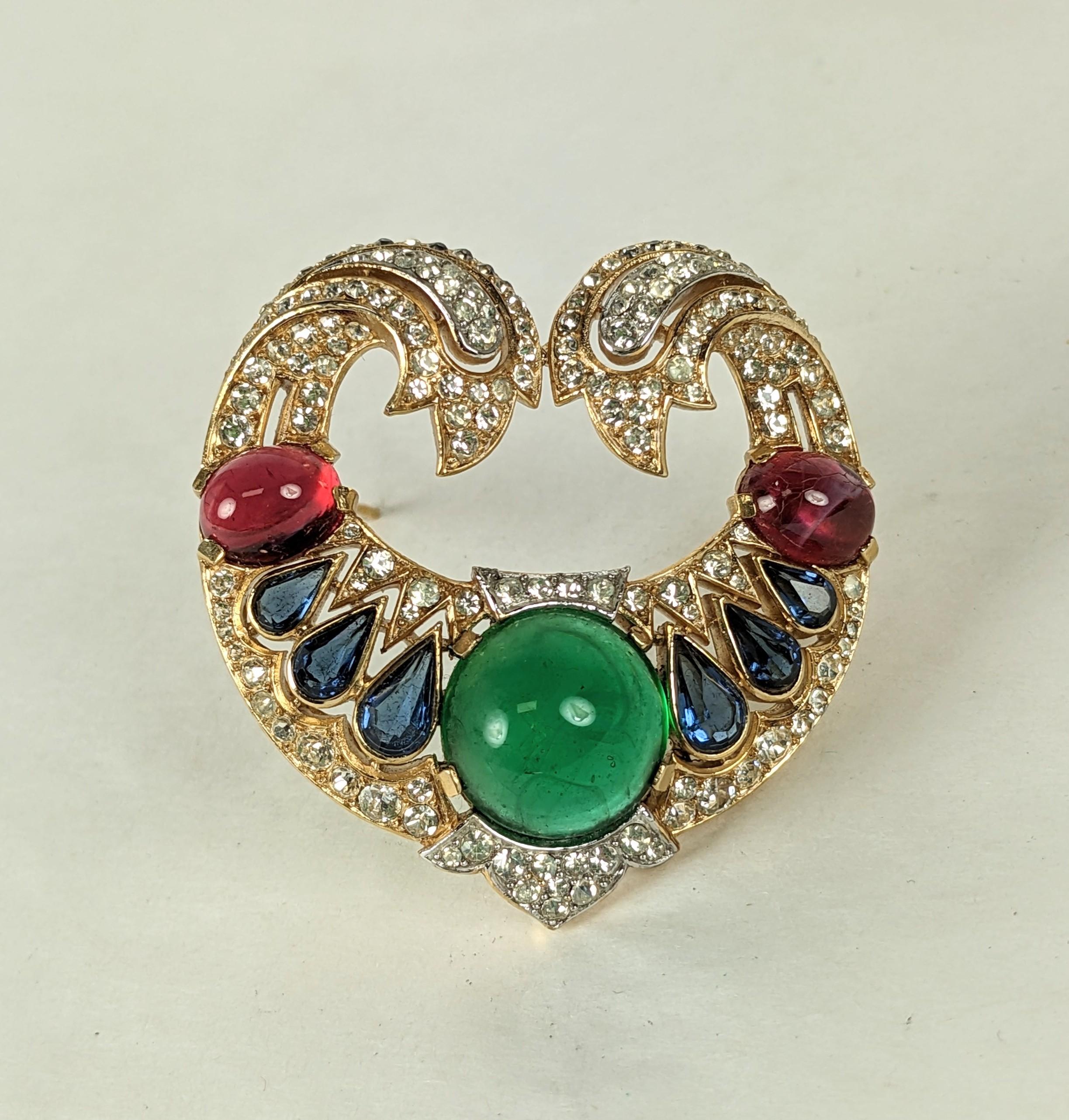 Seltene Trifari Jewels of India Brosche aus der Moghul-Serie. Aufwändige Kristallarbeiten in vergoldetem und rhodiniertem Metall mit Cabochon-Steinen in Juwelenfarben. 
1960er Jahre USA. 2
