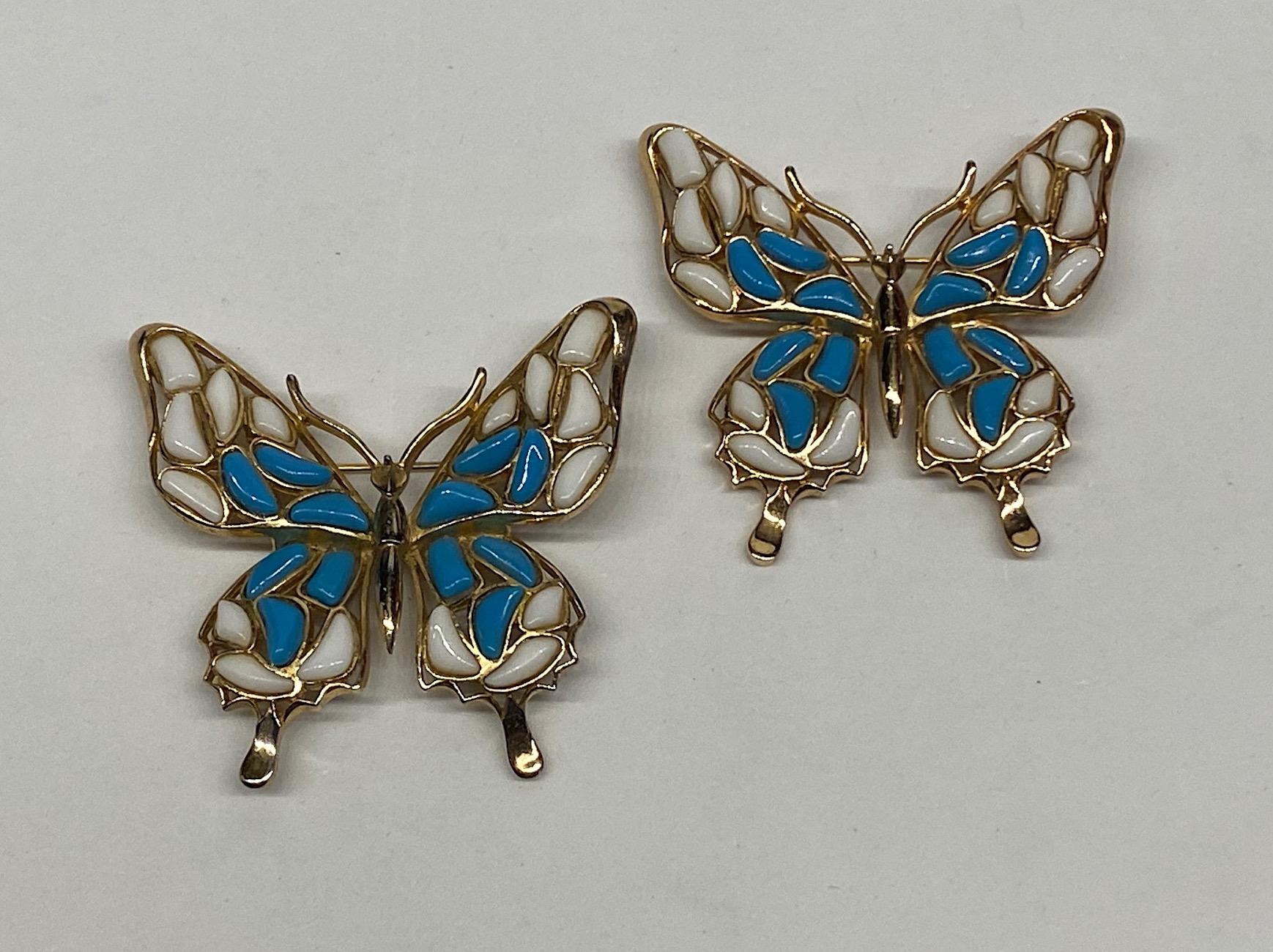 A lovely pair of Trifari butterfly brooches from the 1966 Modern Mosaic line. Each butterfly is hand set with multi shape and size stones in white and turquoise opaque glass. A brooch measures 2 inches wide, 2 inches high and .25 of an inch deep,