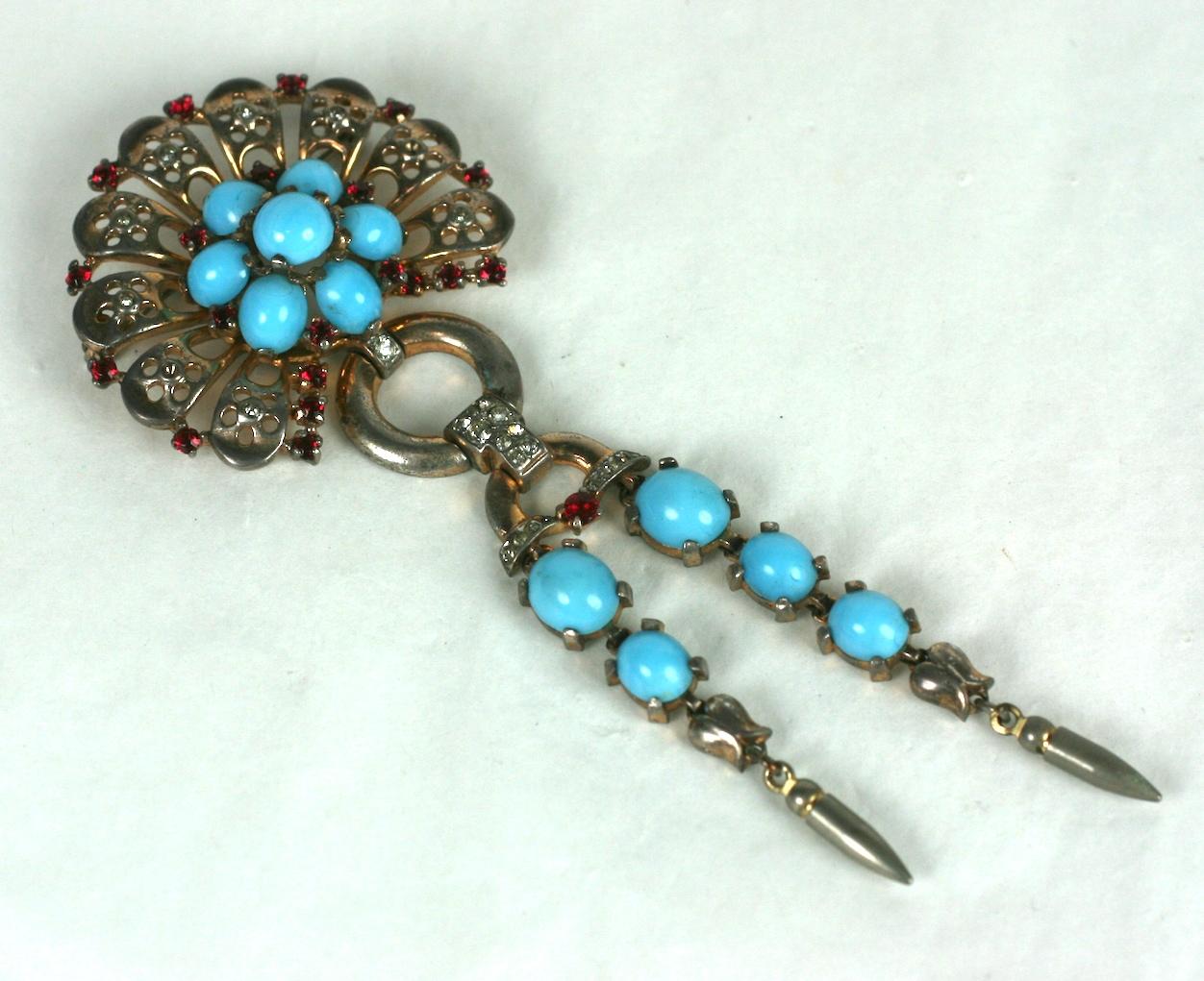 Trifari Retro Sterling Turquoise Dangle Brooch from the 1940's. Retro pierced design with faux cab turquoises and ruby pastes by Alfred Phillipe. Vermeil pink gold finish. 
4.25