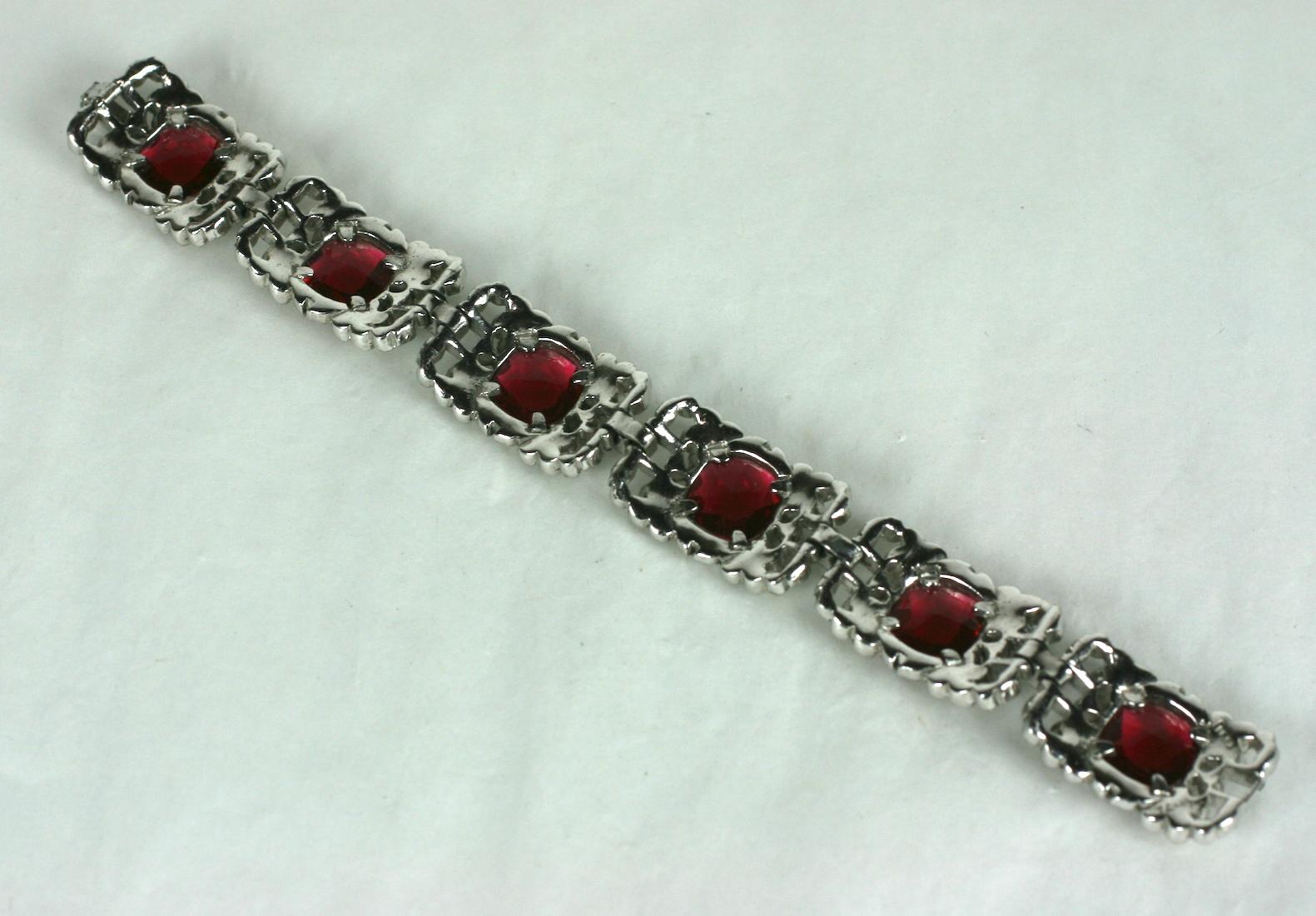 Rare Alfred Phillipe for Trifari Ruby Art Deco Bracelet with pave floral surrounds encasing six large shallow cut faux ruby faceted stones. Pave branches are finely detailed with navy enamel vines and flower heads.  1930's USA.  
Alfred Phillipe for