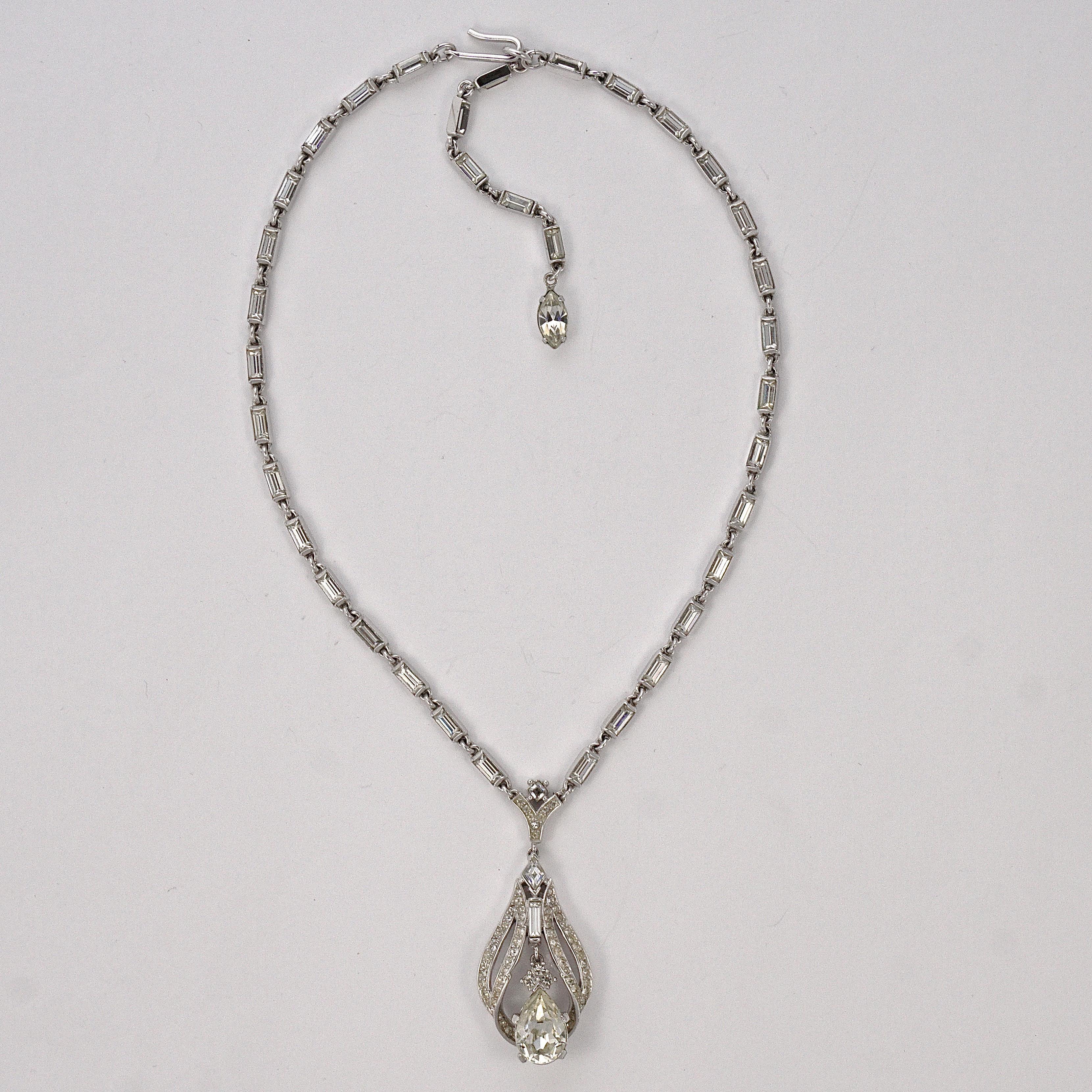 Fabuleux collier Trifari de couleur argent avec baguettes en strass, et avec un pendentif en strass avec une larme tremblante. Le collier mesure 39.4cm / 15.5 inches, et peut être porté à une longueur plus courte en ajustant le crochet. Ce