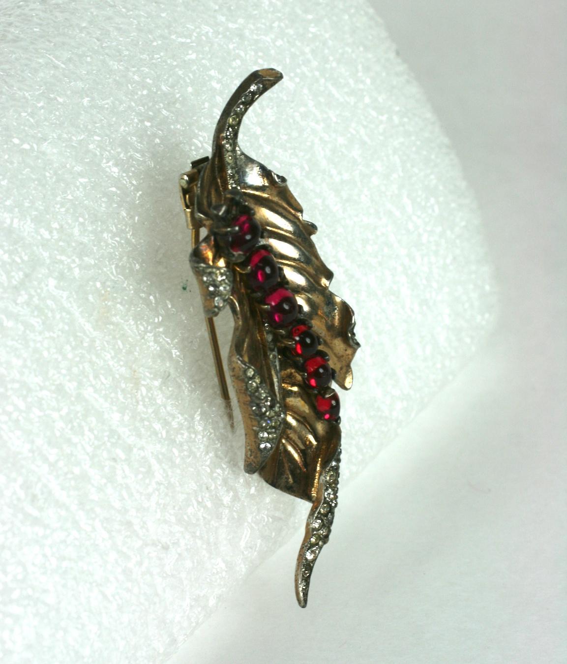 Charming Trifari Sterling Vermeil Caterpillar crawling on Leaf clip from the early 1940's.  A curled leaf with pink gold wash has an applied caterpillar in faux ruby cabochons and baguettes. The leaf is further decorated with pave rhinestone