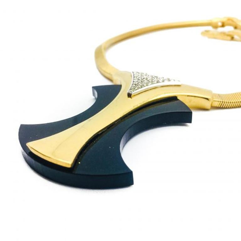 Ein fabelhaftes Stück Trifari aus den 70er Jahren. Diese besondere Trifari-Halskette ist ungewöhnlich, da sie stark stilisiert ist. Das geometrische, schwarze Mittelstück ist geschickt in ein vergoldetes Halsband integriert, das mit Strasssteinen