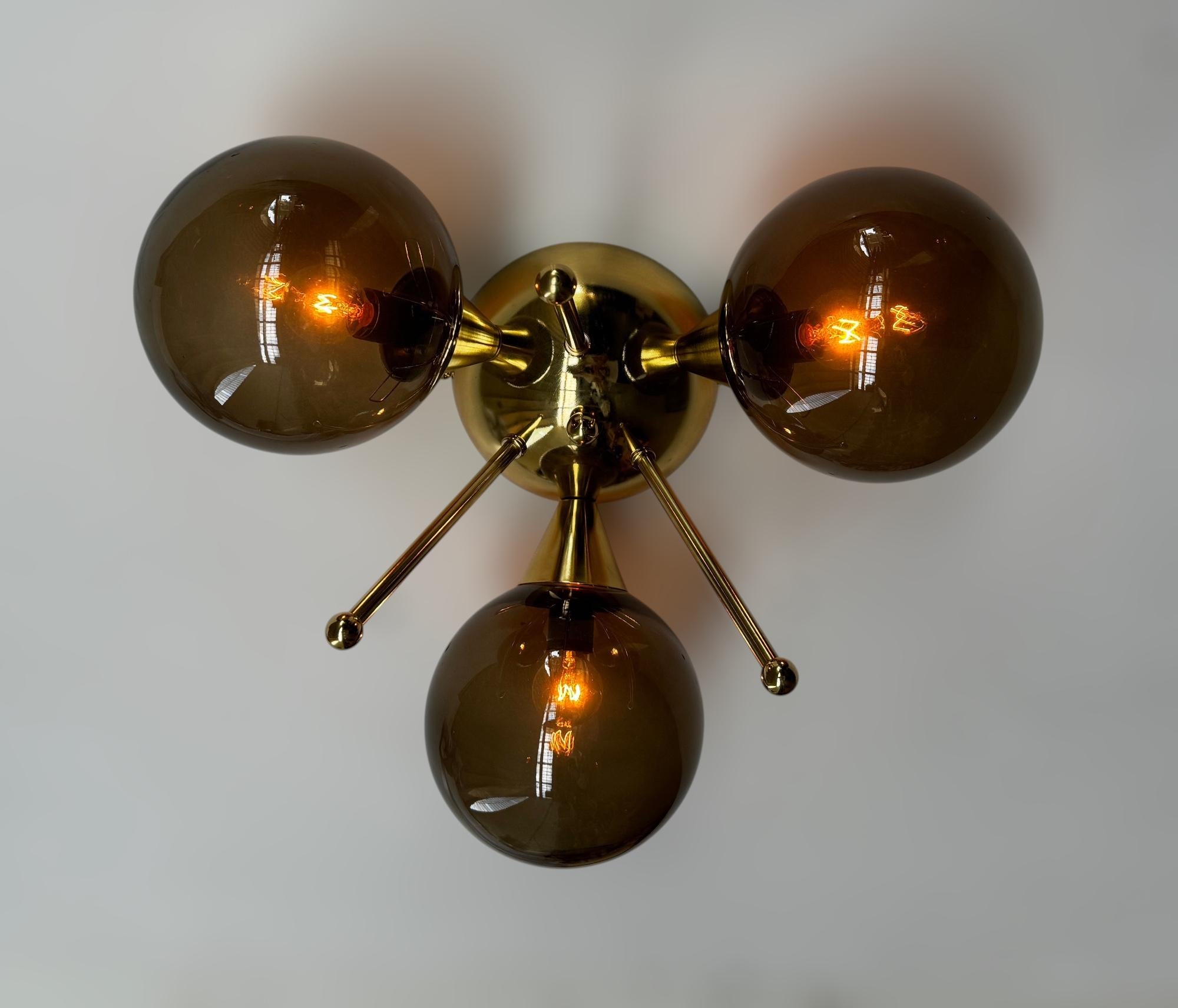 Montatura da incasso italiana con 3 globi in vetro di Murano montati su una struttura in ottone massiccio con finitura in ottone laccato lucido
Disegnato da Fabio Bergomi / Made in Italy
3 luci / tipo E12 o E14 / max 40W ciascuna
Diametro: 13