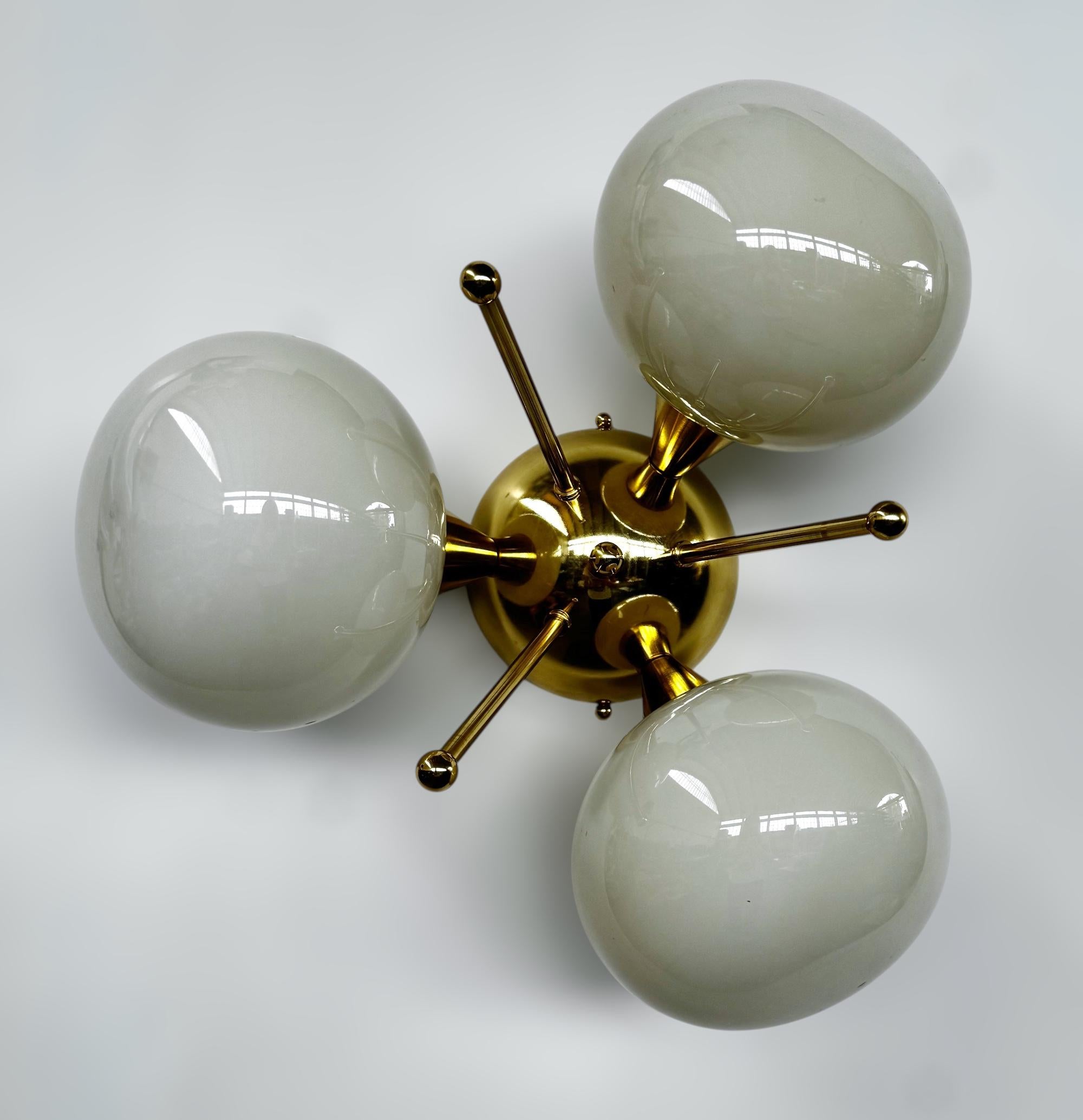 Lampada da incasso italiana con 3 paralumi in vetro di Murano a forma di ciottolo montati su una struttura in ottone massiccio con finitura in ottone laccato lucido.
Disegnato da Fabio Bergomi / Made in Italy
3 luci / tipo E12 o E14 / max 40W