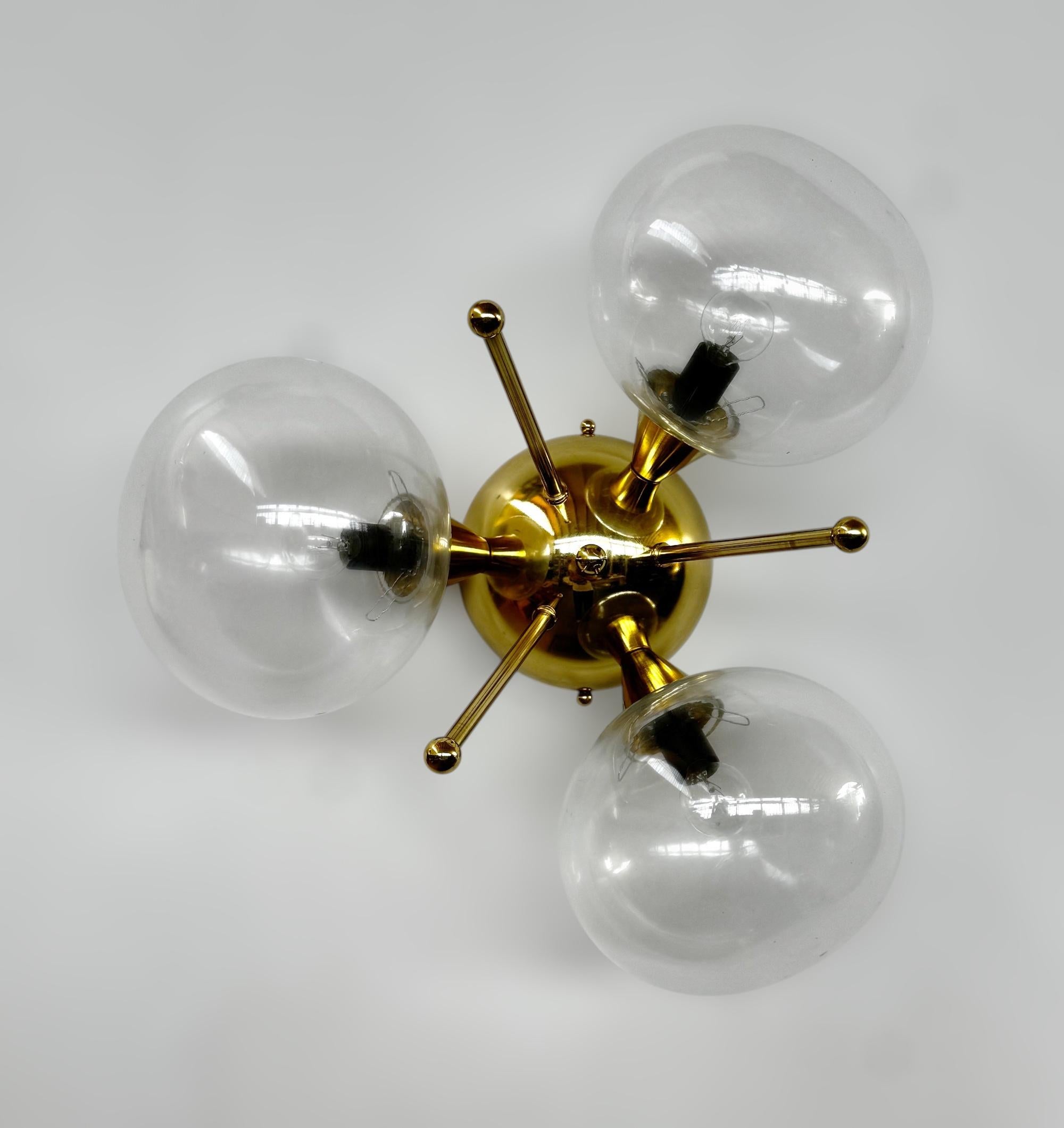 Lampada da incasso italiana con 3 paralumi in vetro di Murano a forma di ciottolo montati su una struttura in ottone massiccio con finitura in ottone laccato lucido.
Disegnato da Fabio Bergomi / Made in Italy
3 luci / tipo E12 o E14 / max 40W