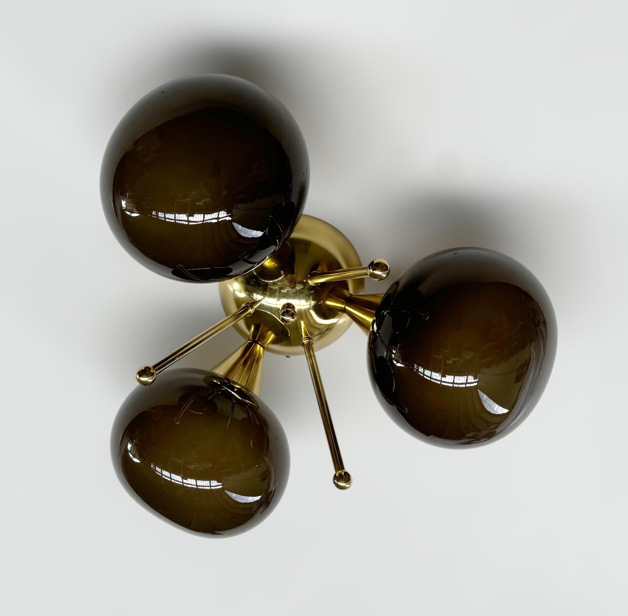 Lampada da incasso italiana con 3 paralumi in vetro di Murano a forma di ciottolo montati su una struttura in ottone massiccio con finitura in ottone laccato lucido.
Disegnato da Fabio Bergomi / Made in Italy
3 luci / tipo E12 o E14 / max 40W