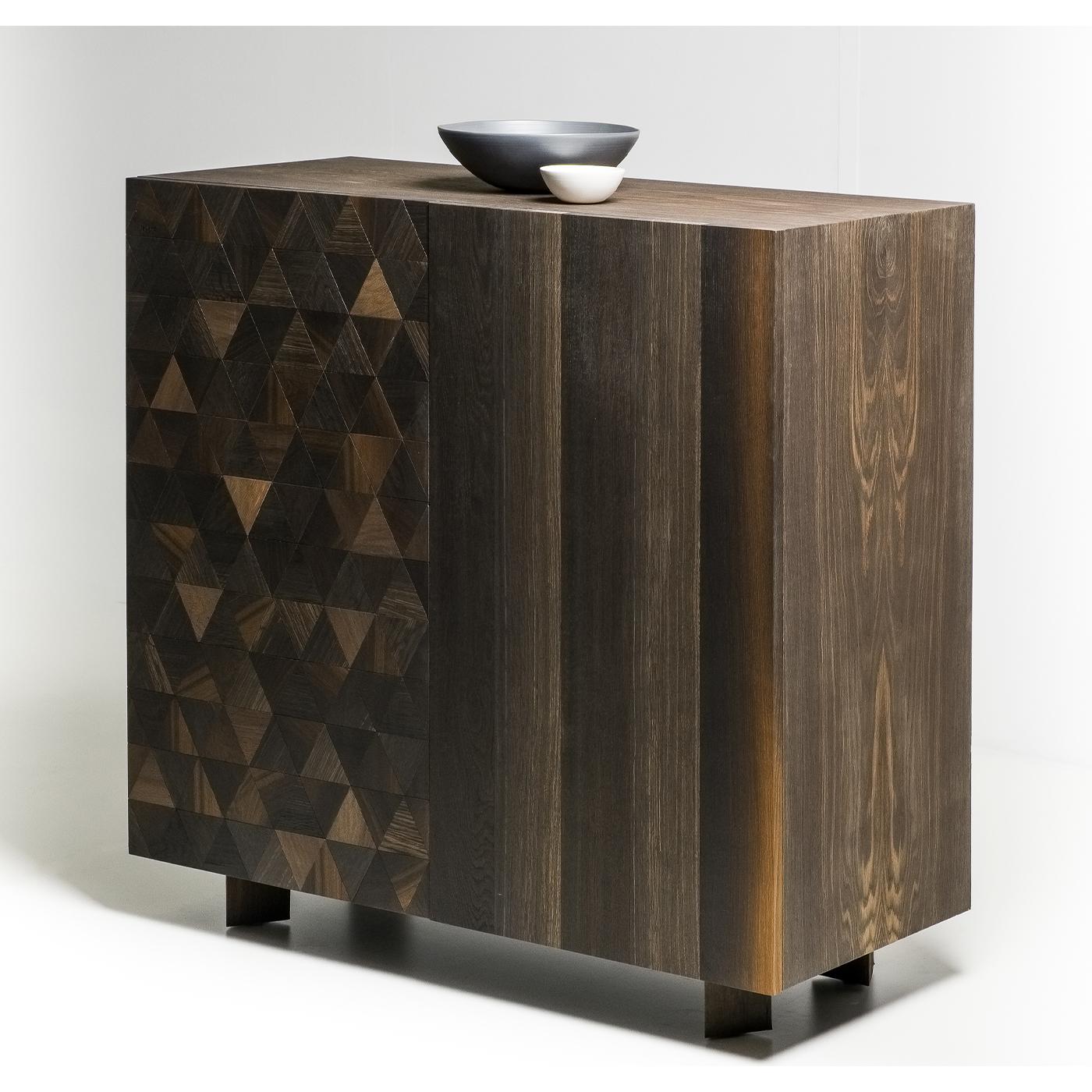 The structure and doors are made from Fossil Oak. The triangular feet reflect the same design and size as the triangular doors. The shelf is 1cm thick tempered glass. The finishing is water based oil with beeswax. Two distinct designs on the doors: