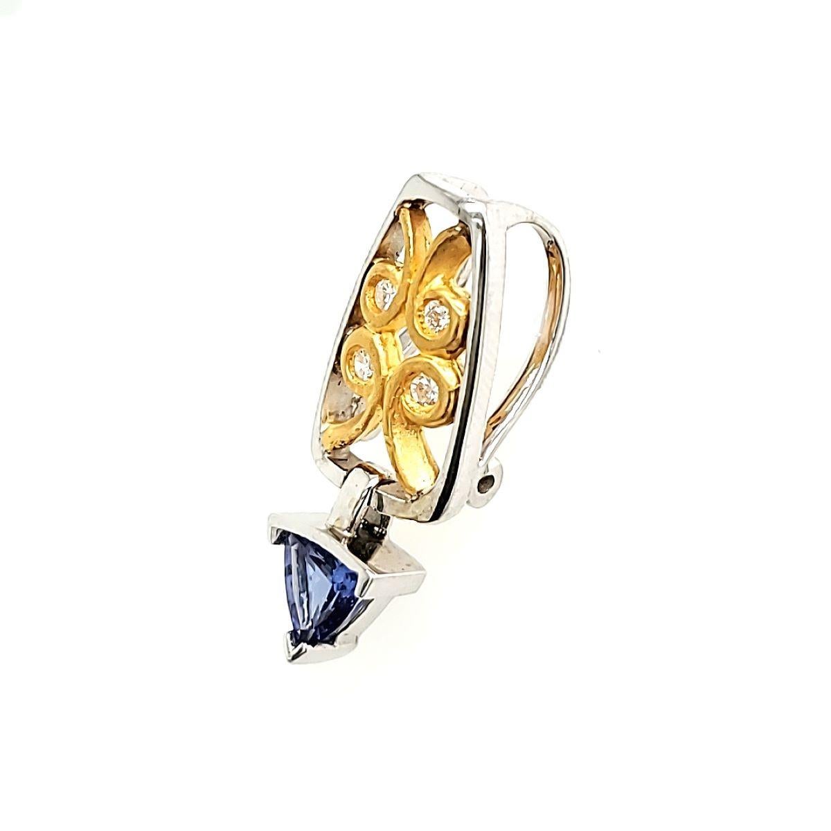 This pendant is a show-stopping piece that adds a touch of glamour to any outfit.

It is expertly crafted and has a breathtaking 0.73 carat triangle-shaped Tanzanite suspended elegantly by a bale embellished with an alluring swirl yellow gold