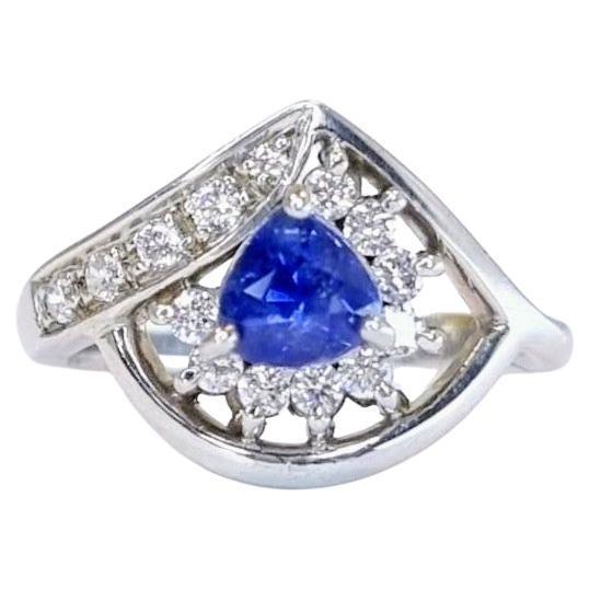 This 6.8mm x 6.6mm Statement Ring features a 1ct trillion-cut blue sapphire as its centerpiece. The trillion cut, a triangular faceting style, enhances the sapphire’s deep blue color and brilliance through its unique geometry, making it a standout