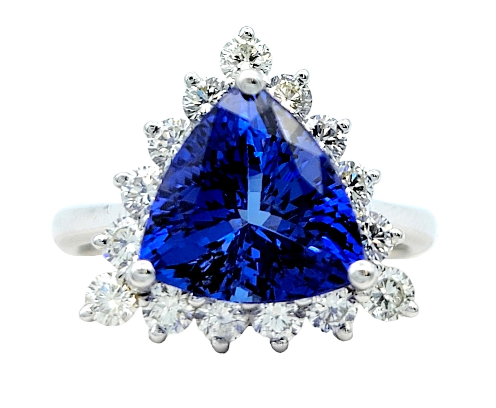 Ring size: 6.5

This exquisite trillion-cut tanzanite ring, adorned with a dazzling diamond halo, is a true embodiment of elegance and charm. The beautiful tanzanite centerpiece boasts a mesmerizing violetish- blue color that absolutely radiates on