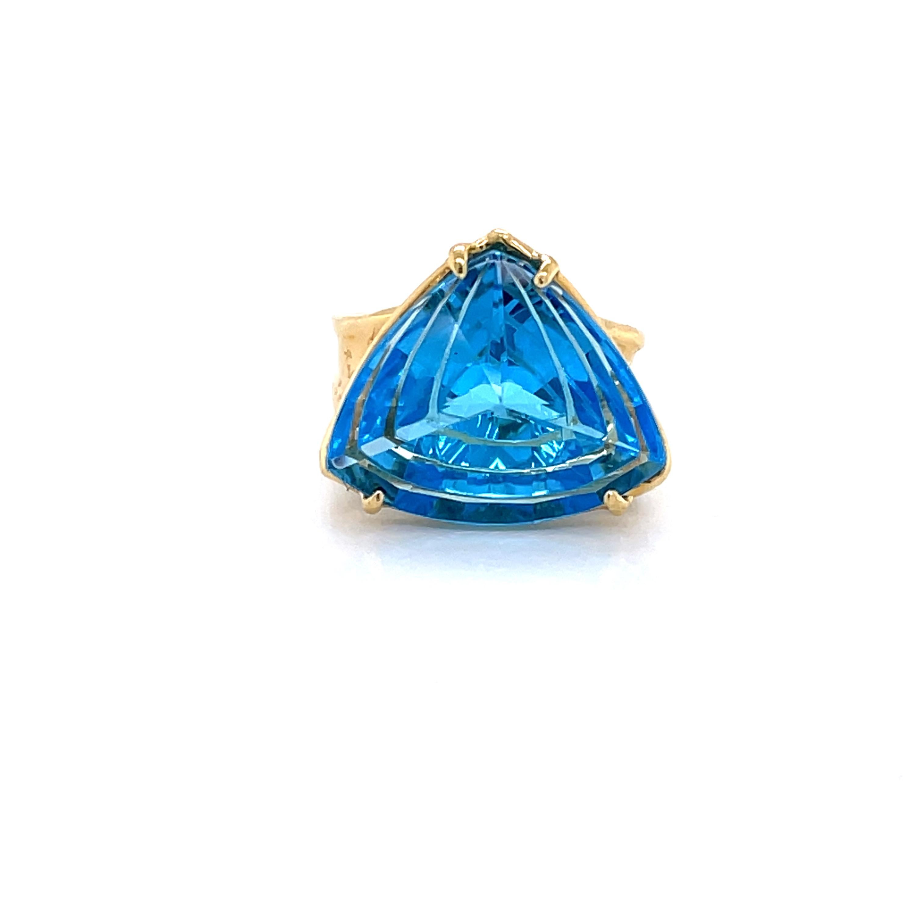 Show off this vivid blue fantasy cut trillion topaz, perfect for a pinky ring or ring finger. The unique shape of the stone is presented in a floating setting to appreciate it's depth of color. The ring is made with a graduated 3.8 -5.8mm flared 18