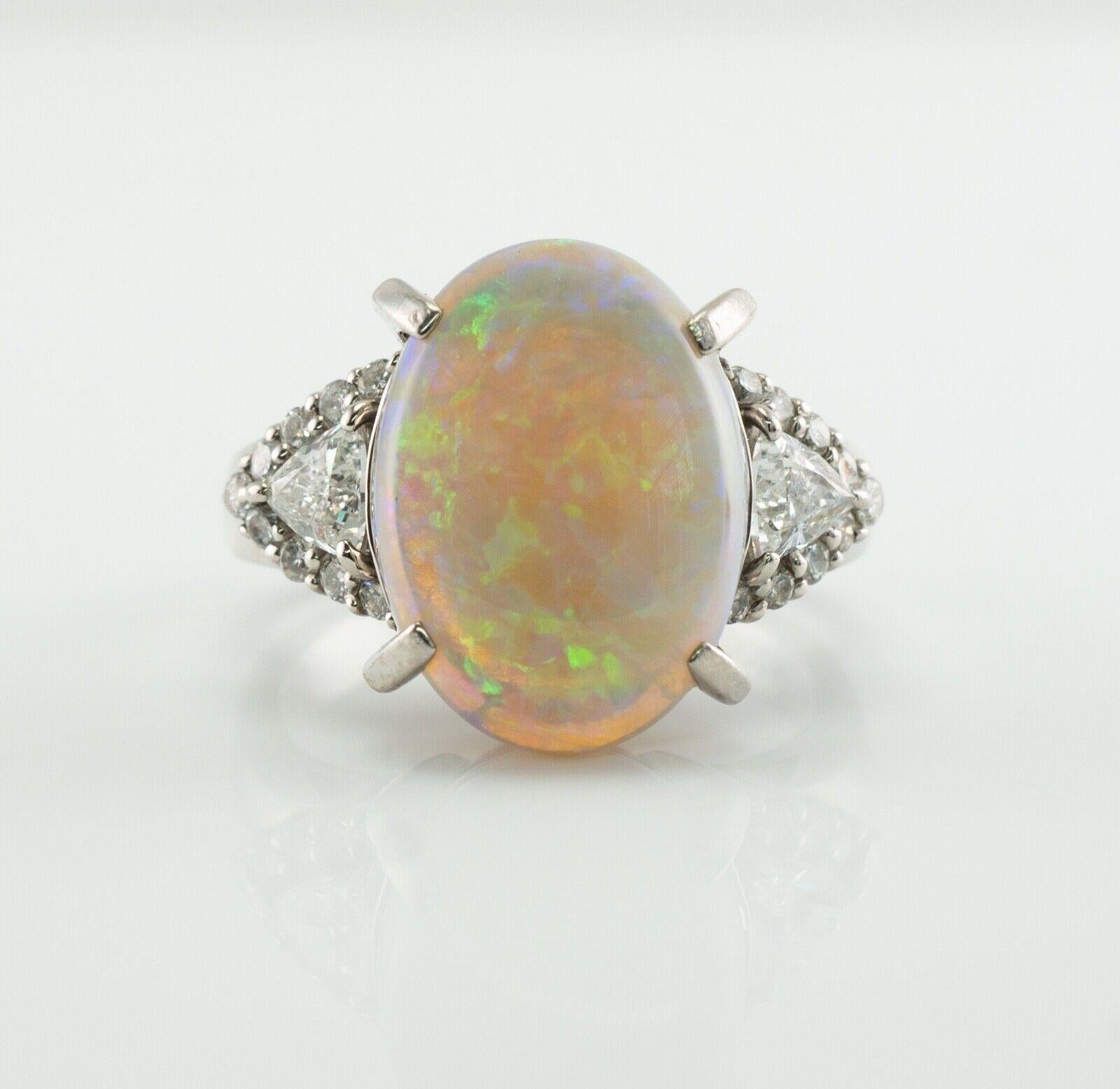 Trillion Cut Diamond Opal Ring Platinum

This estate ring is made in solid Platinum and set with genuine Opal and diamonds.
The center Earth mined Opal measures 14mm x 10mm (3.90 carats). 
It has splashes of electric green, blue, orange colors! 
Two