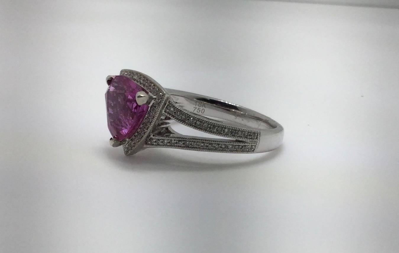 18K white gold ring with Trillion cut Pink Sapphire and Diamonds. The pink sapphire trillion weighs 3.16 carats. The split shank mounting contains 89 diamonds weighing combined 0.24 carat. The ring is size 6.5 and can be sized.

