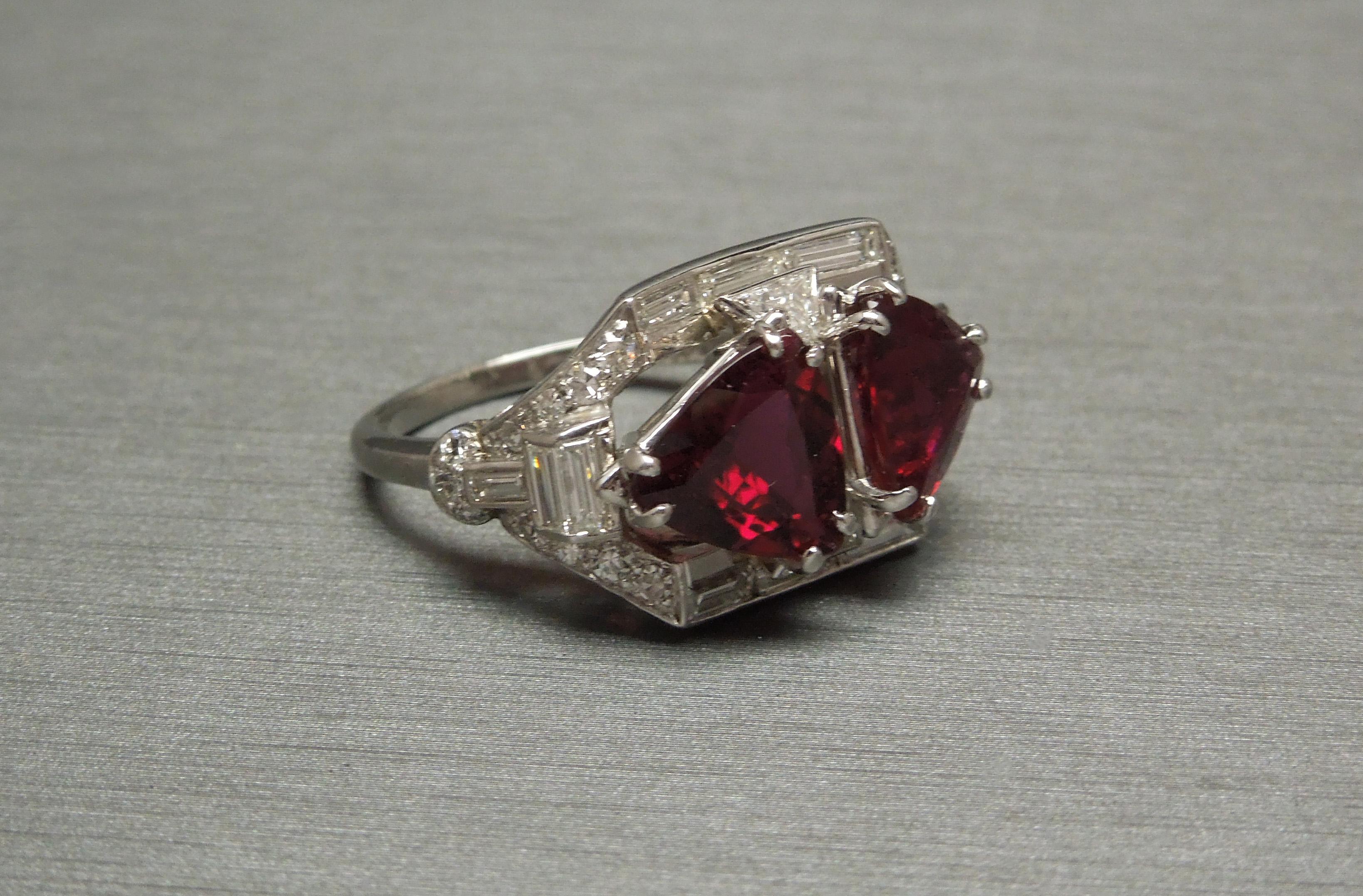 This Platinum Rubellite & Diamond ring features two focal Trillion cut Rubellites, a.k.a. Red Tourmalines totaling 4.12 carats each securely set in three doubled prongs. With a total of 2.50 carats of Diamonds consisting of Colorless Nearly Flawless