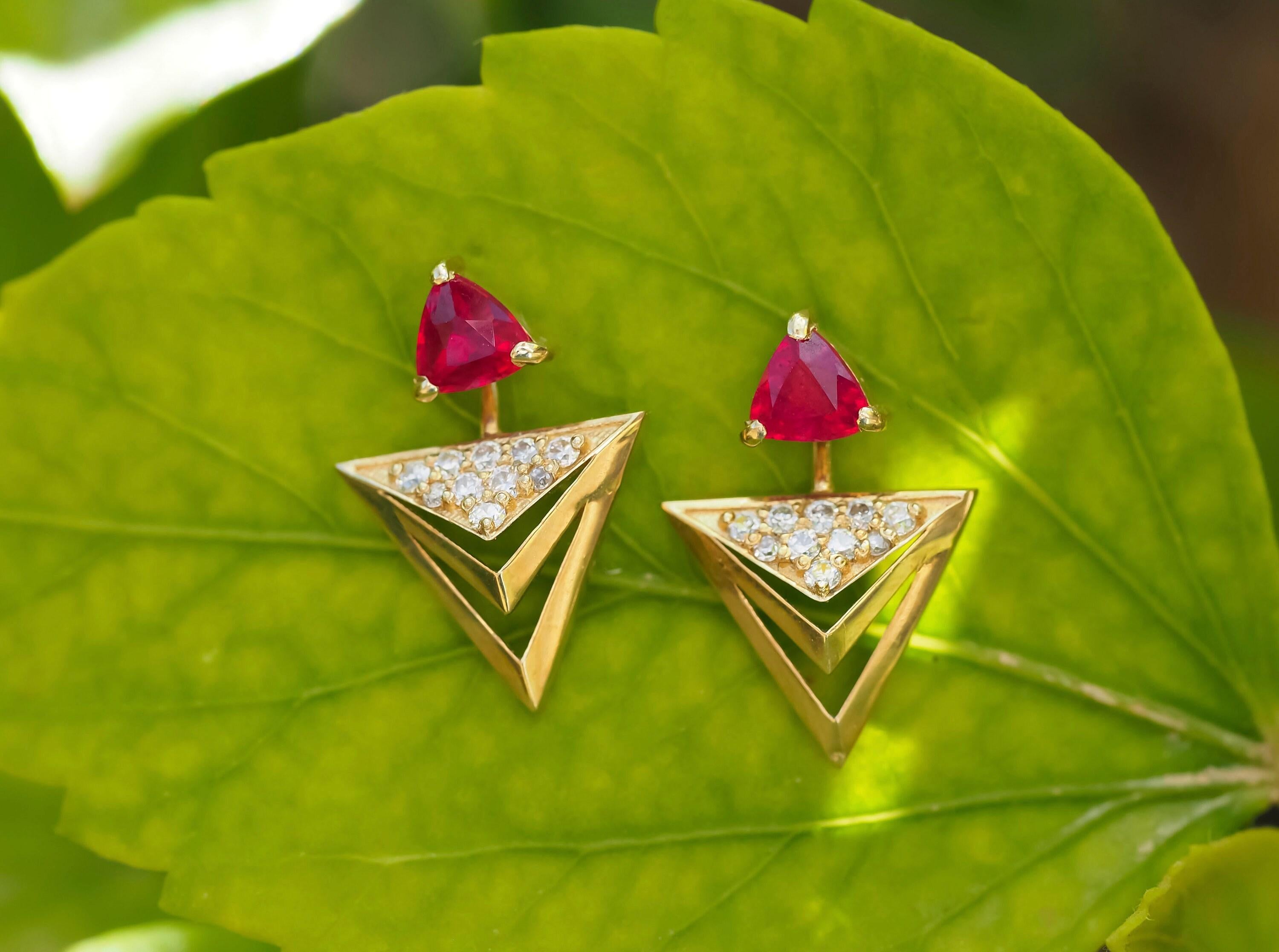 Trillion cut ruby stud earrings in 925 silver.

Metal type: 925 silver
Size: 16 x 11 mm.
Weight: 2 g.

Central stones:
2 Rubies: red color, Trillion /trilliant cut, clarity - transparent, 0.45x2=0.90 ct total

Side stones:
Diamonds: 20 pieces, round