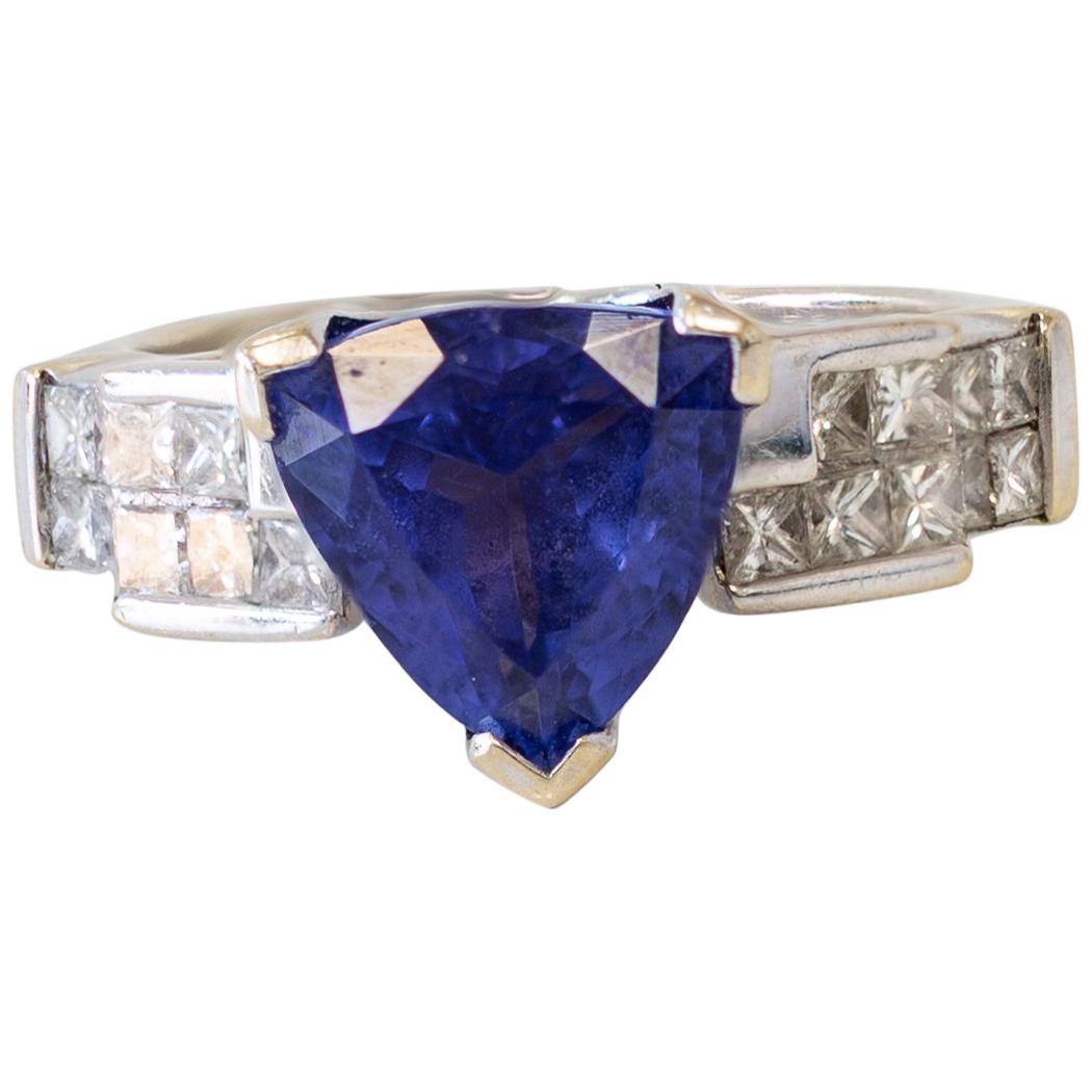 Anillo de oro blanco de 18 quilates con tanzanita talla trillón y diamantes talla princesa