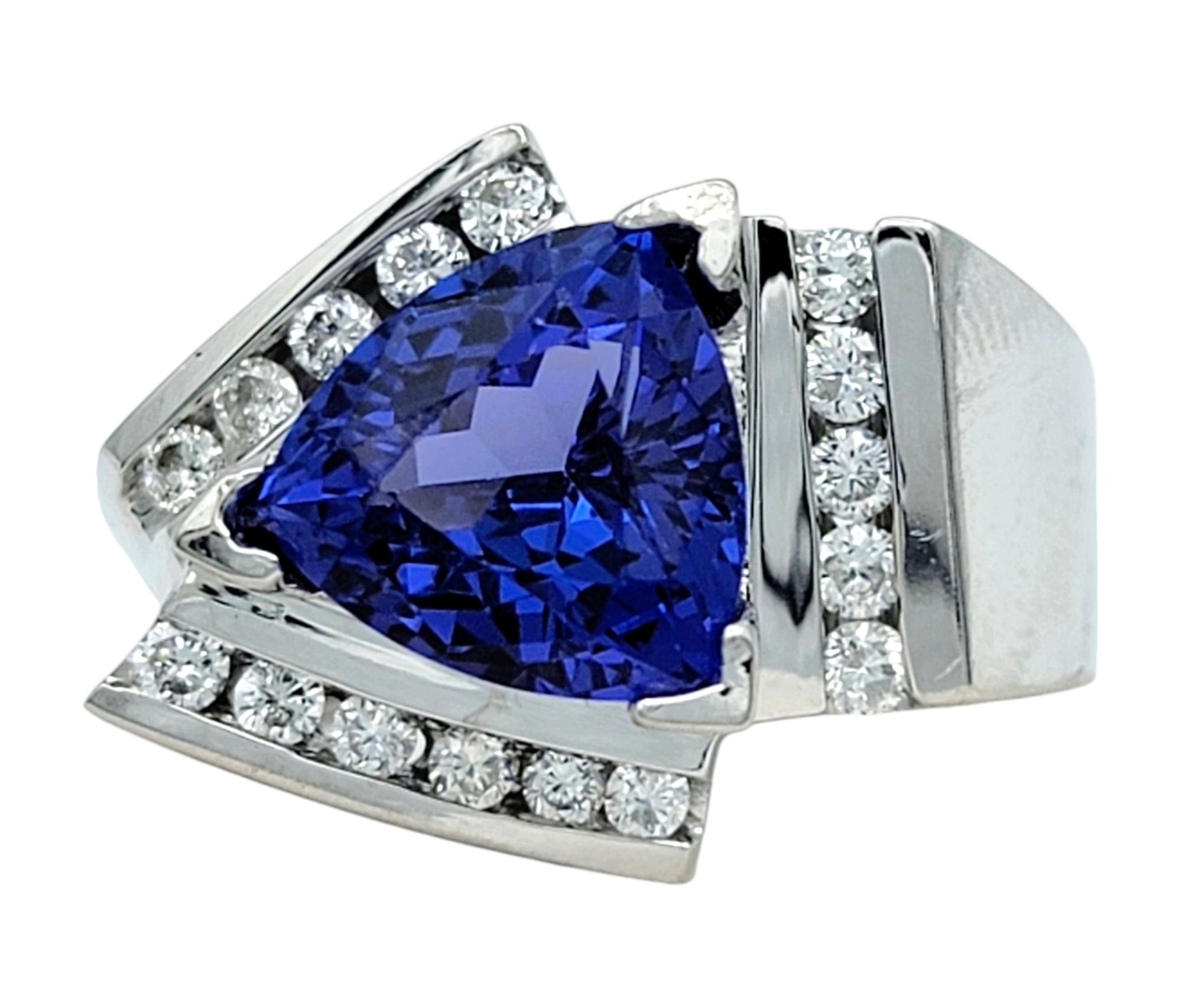 Ring Size: 5.5 

Step into the world of modern elegance with this stunning ring, featuring a captivating trillion cut tanzanite at its heart. This rare, deeply hued gemstone shimmers with an intense violet-blue that shifts with every angle, creating