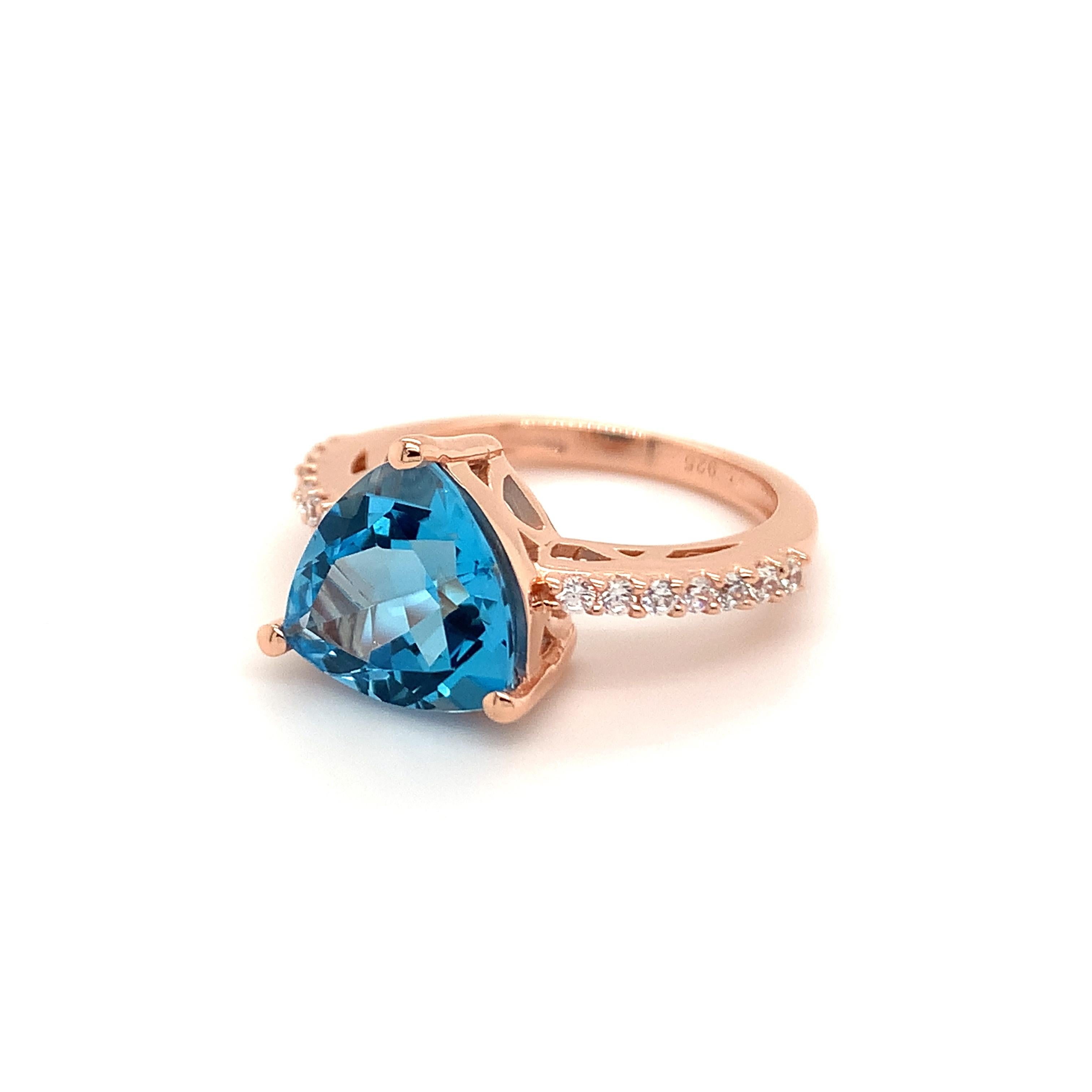 Trillion Shape Swiss Blue Topaz Gemstone beautifully crafted with CZ in a Ring. A fiery Blue color December Birthstone. For a special occasion like Engagement or Proposal or may be as a gift for a special person.

Primary Stone Size - 10x10mm