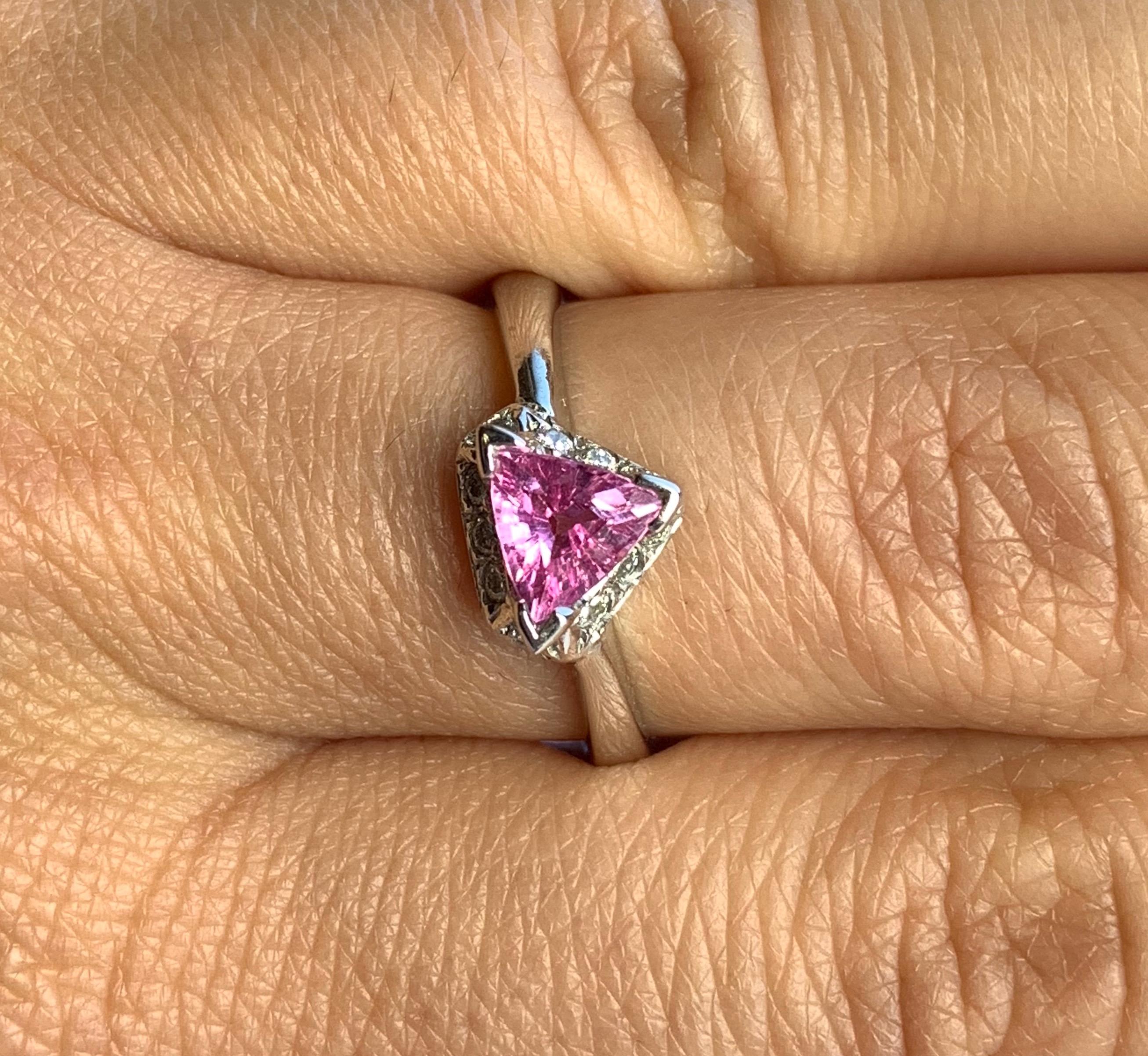 Material: 14k White Gold 
Center Stone Details: 0.72 Carat Trillion Cut Pink Sapphire 
Mounting Diamond Details: 11 Round White Diamonds Approximately 0.15 Carats - Clarity: SI / Color: H-I
Ring Size: 6.25. Alberto offers complimentary sizing on all