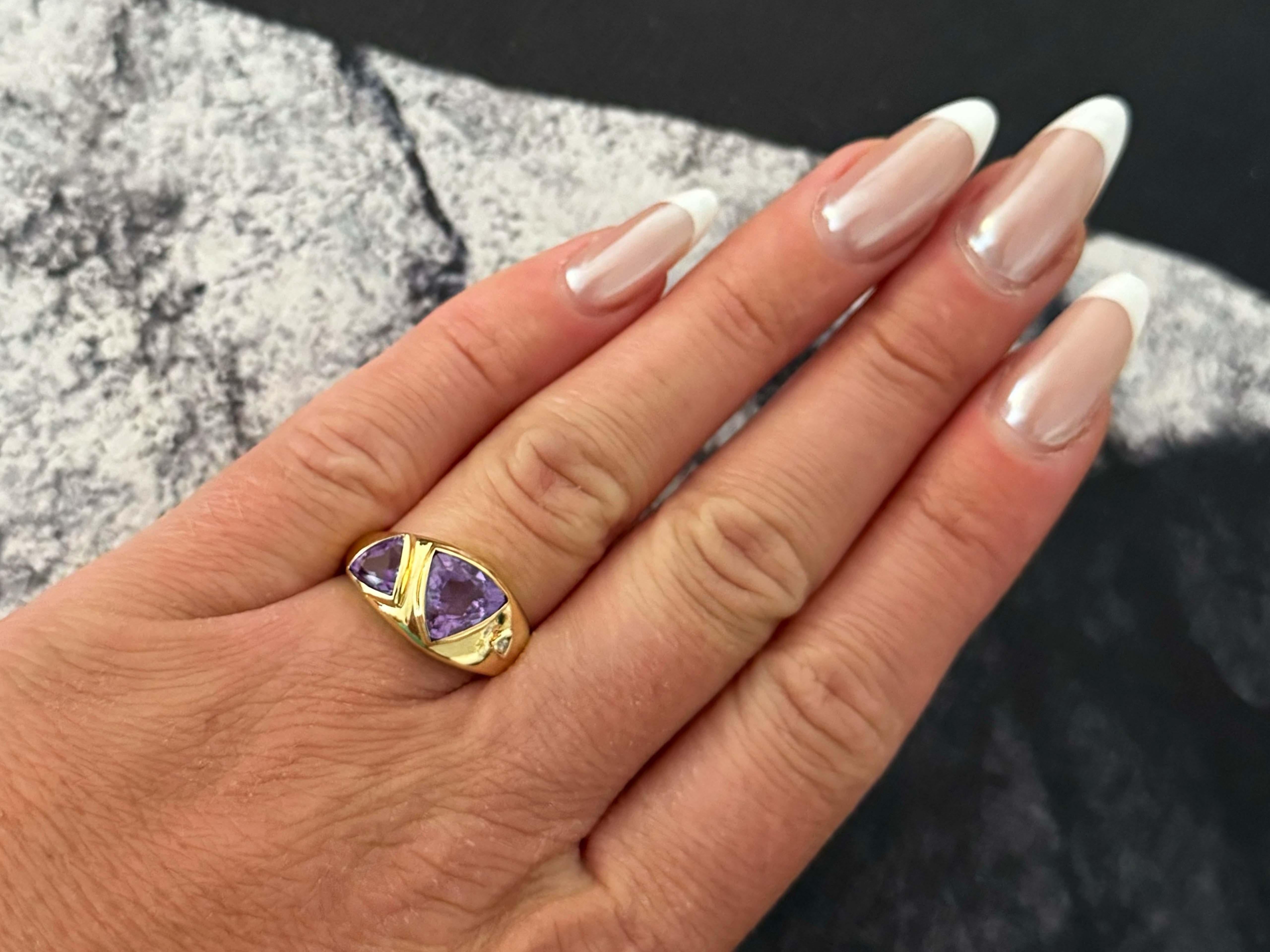 Ring Specifications:

Metal: 14k Yellow Gold

Total Weight: 4.1 Grams
​
​Diamond Count: 1
​
​Diamond Clarity: I1
​
​Diamond Color: I

Gemstone: 2 trillion cut amethyst 
​
​Amethyst Carat Weight: ~3.90 carats

Ring Size: 6.75 (resizable)

Stamped: