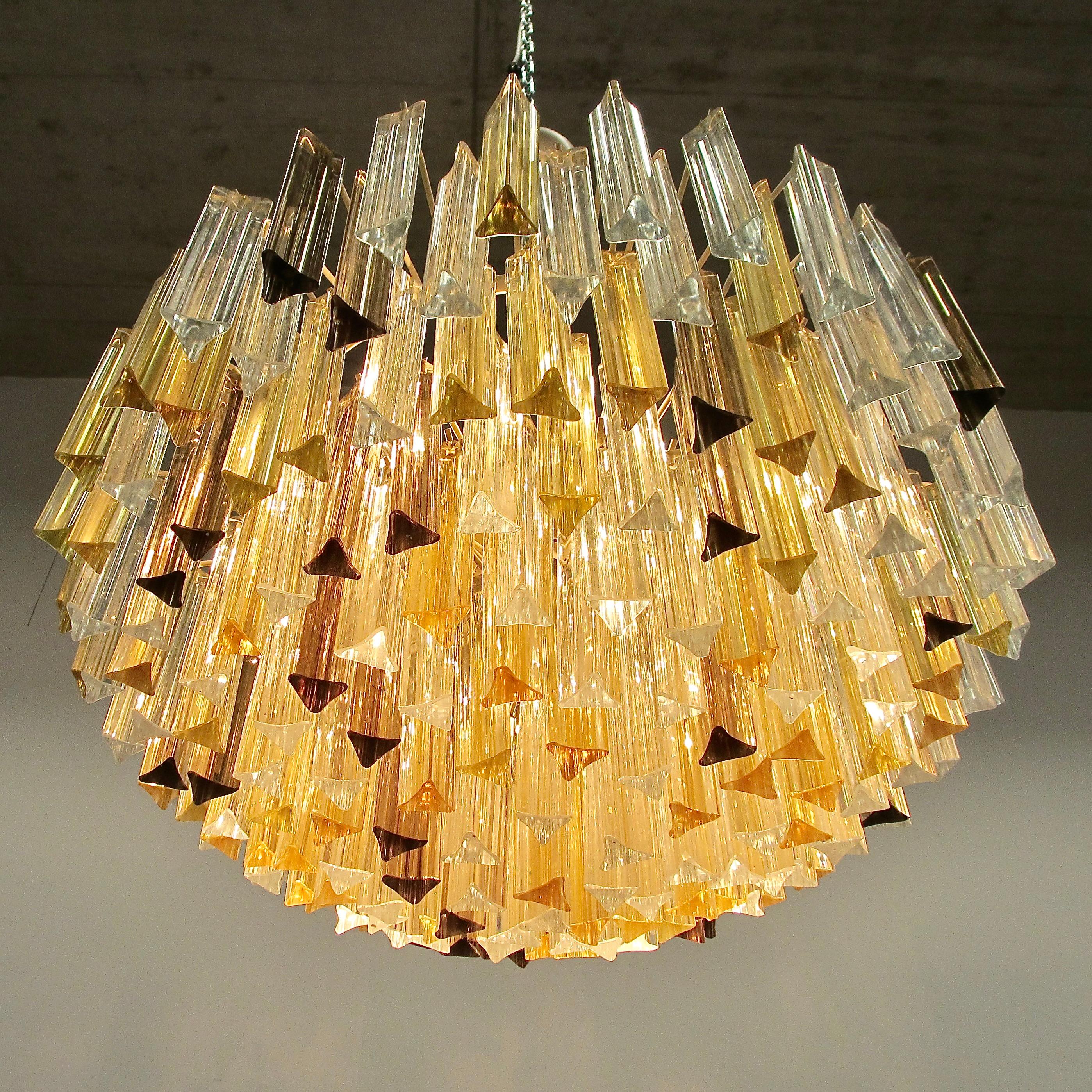 'TRILOBI' glass chandelier. Italy, Murano.

Large glass chandelier with clear and amber coloured 'Trilobi' glass made in Murano, c. 1980. Multi-tier glass chandelier with cream coloured frame, nine E15 light fittings and Trilobi glass pieces.