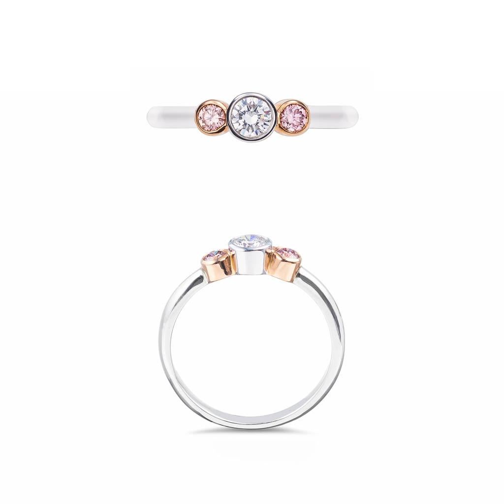 Handmade Euphoria design 18ct white gold and yellow gold Argyle pink and white diamond ring.
This classic Trilogy ring features two beautiful Argyle Pink diamonds and one white centre diamond , symbolising your relationship's past, present &